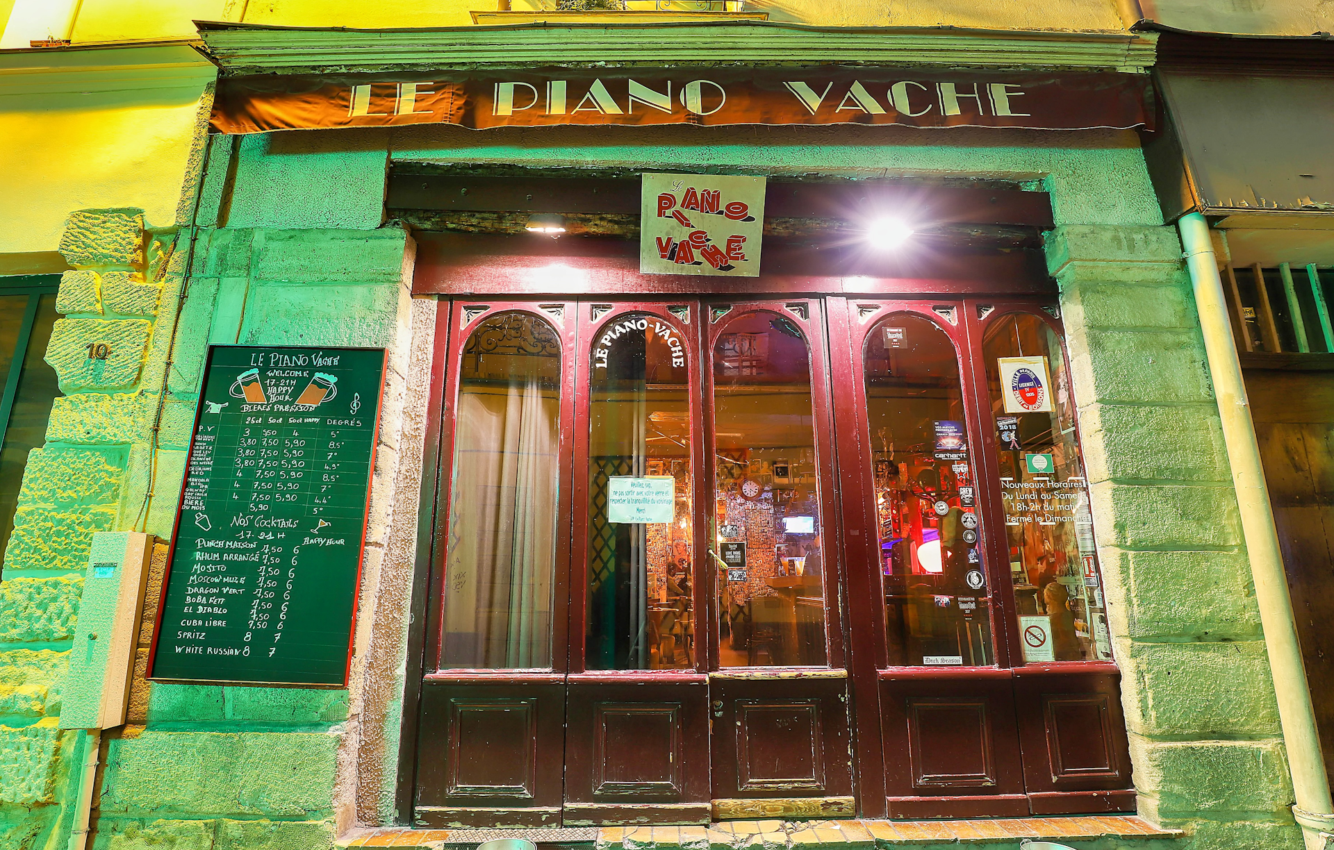 Exterior shot of classic French cafe at night, Le Piano Vache