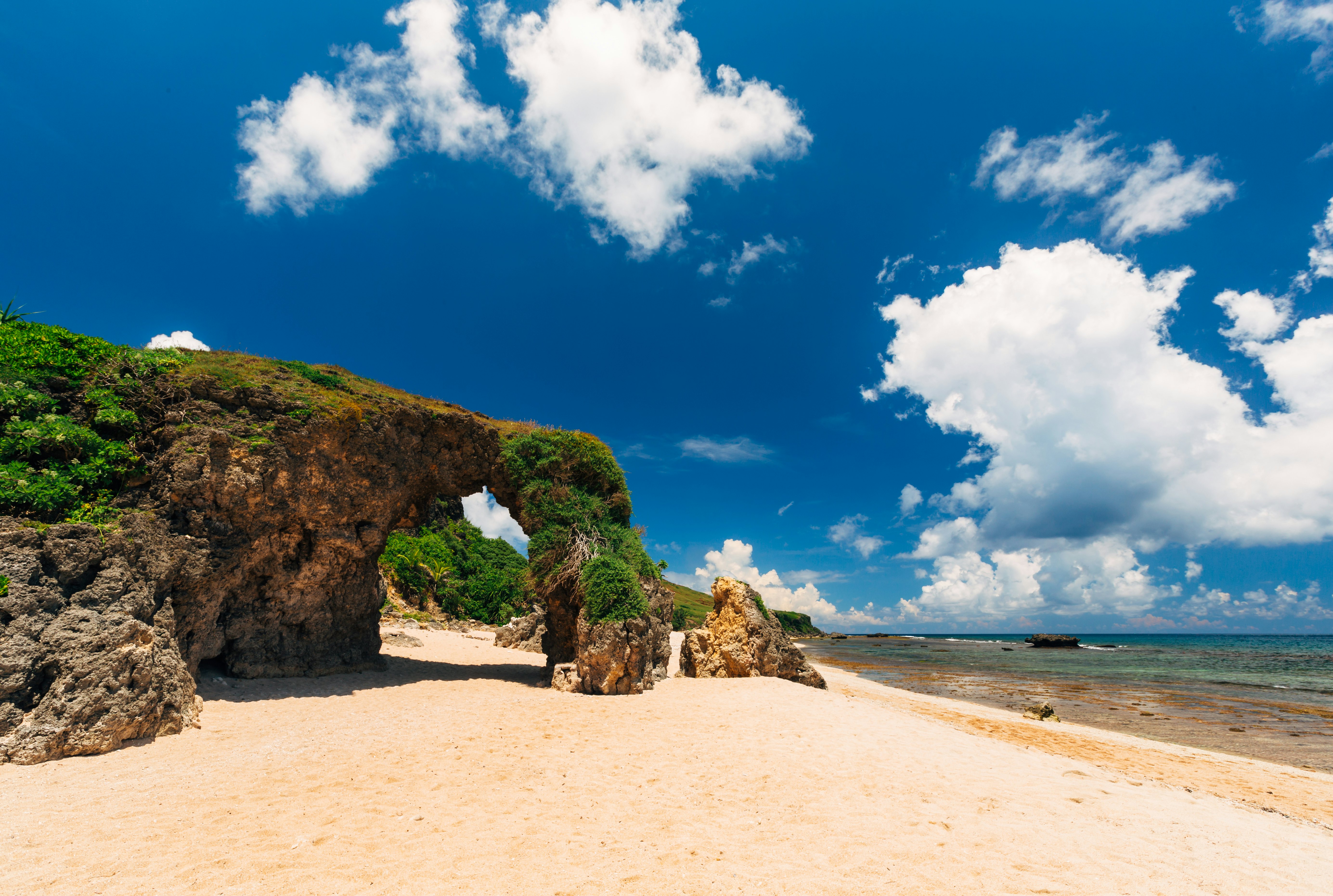 A view of a sandy beach through a rock arch on Sabtang Island, Philippines