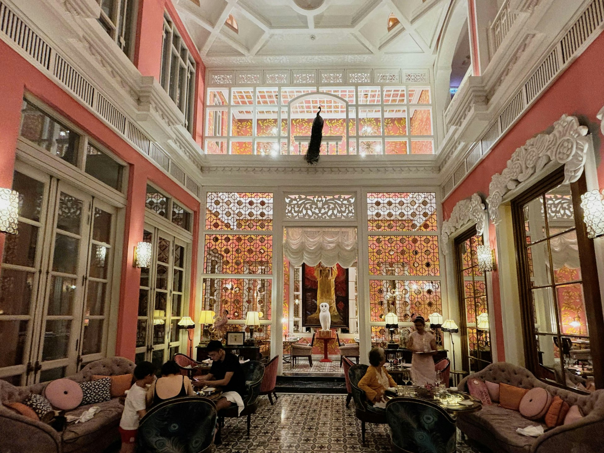 Inside the Pink Pearl Restaurant, with opulent decor including sofas scattered with cushions and intricately molded window frames 