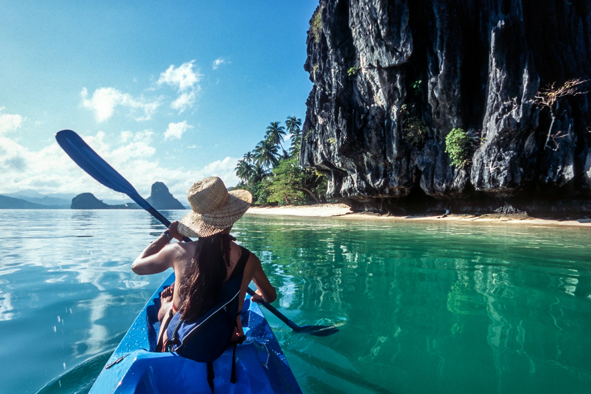 A kayaker approaches a hidden beach at El Nido, Philippines 