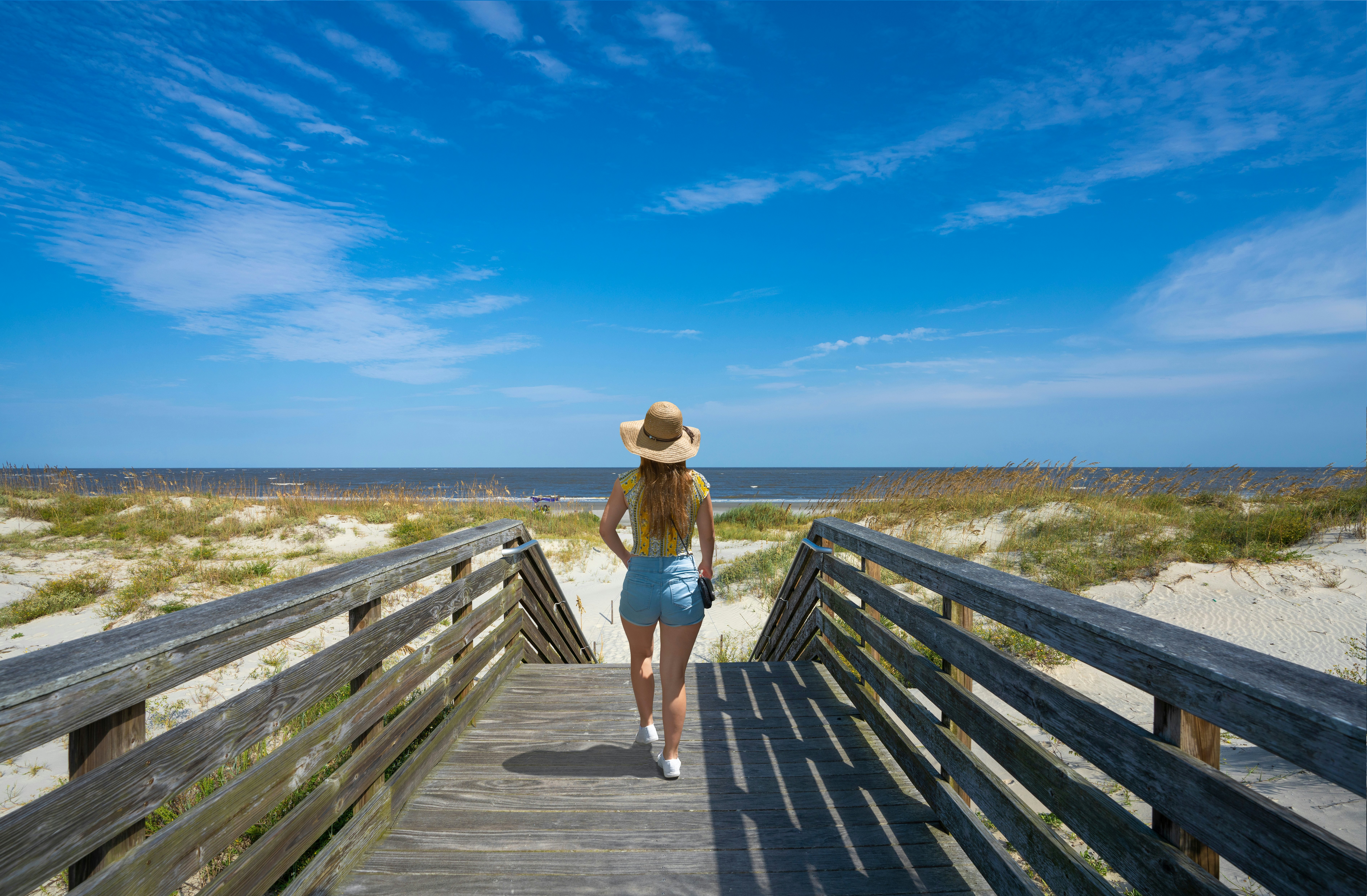 Girl walking on boardwalk to the beach on Jekyll Island, Georgia