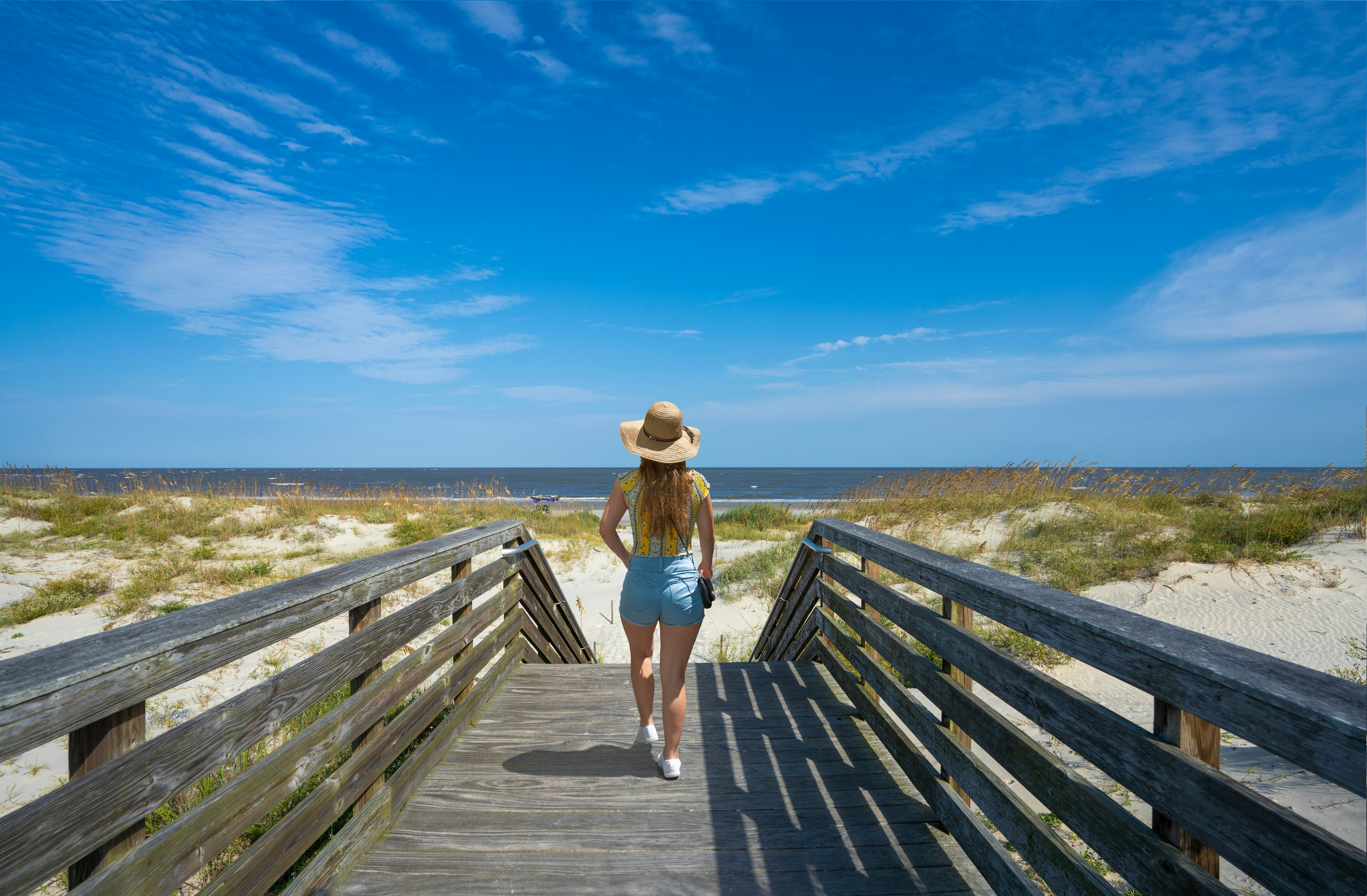 Girl walking on boardwalk to the beach on Jekyll Island, Georgia