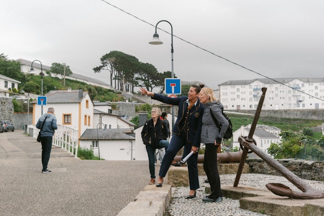 A tour guide points out something of interest to a tourist