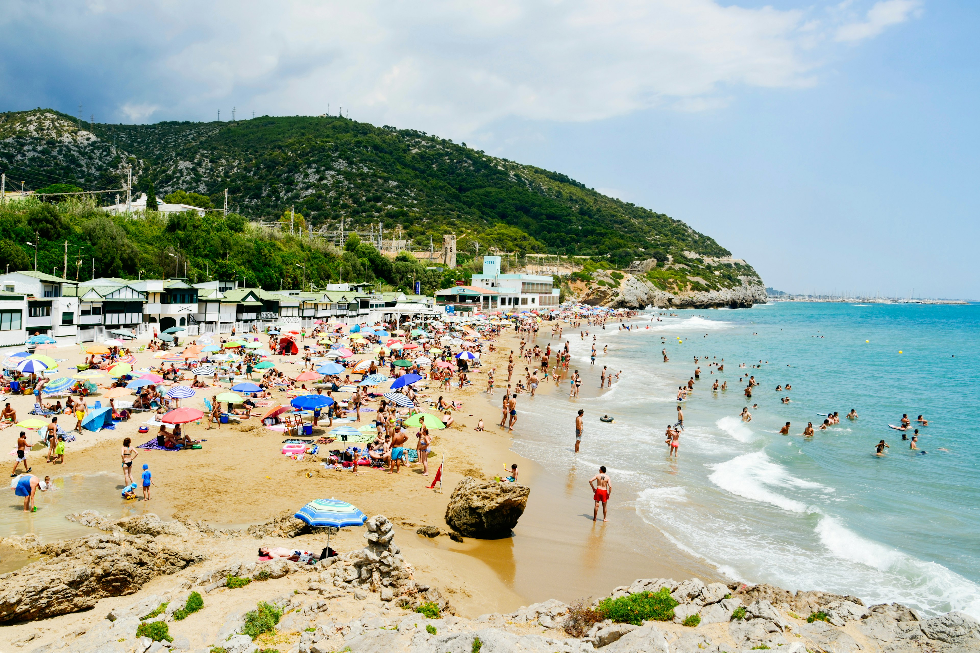 People enjoying, relaxing, sunbathing or bathing at Garraf Beach, Sitges, Catalonia, Spain
