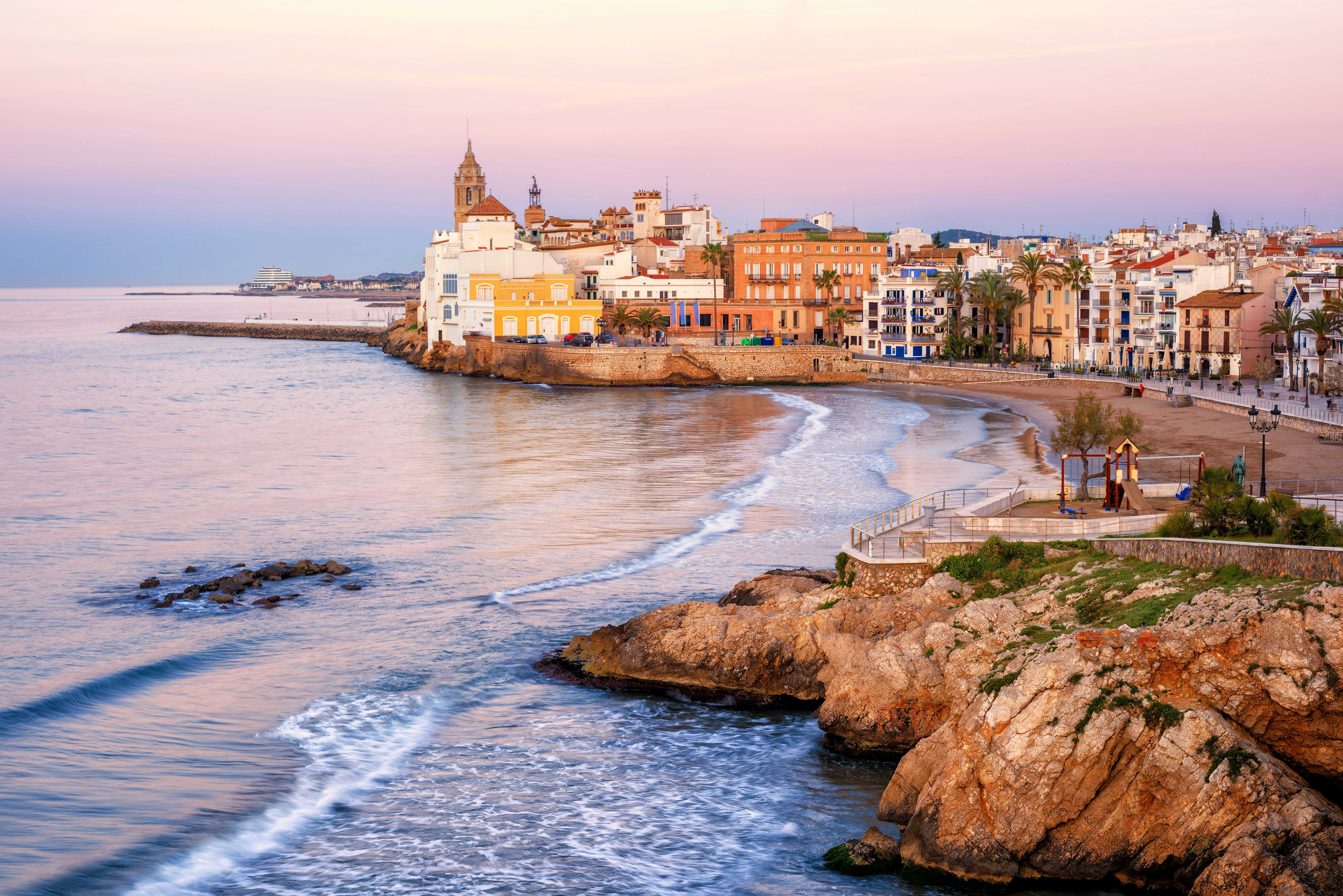 A view of the beach and the old town on the Mediterranean at sunrise, Sitges, Catalonia, Spain