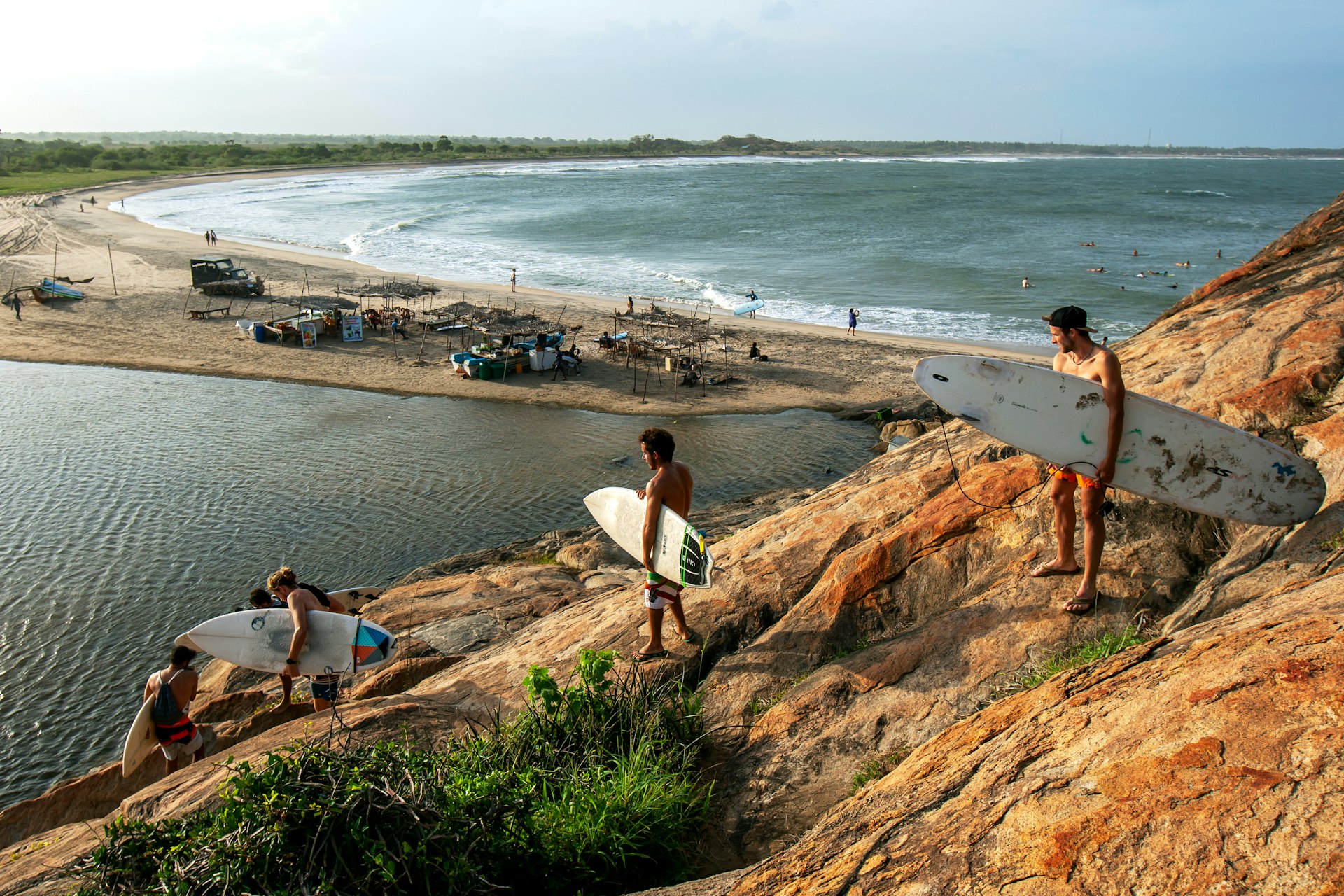 Young surfers carrying their boards to the beach in Sri Lanka