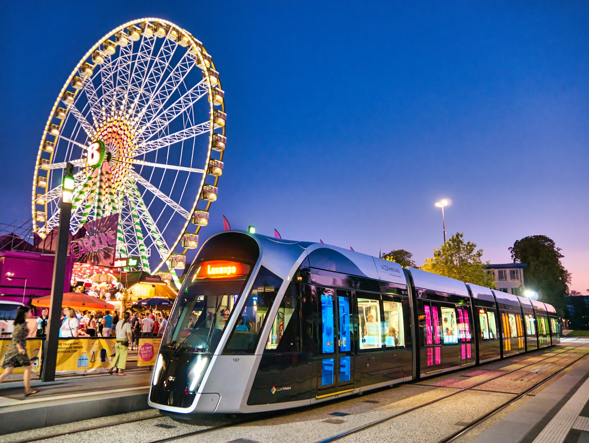 View on Schueberfouer - annual traditional fair of Luxembourg and a tram passing nearby;