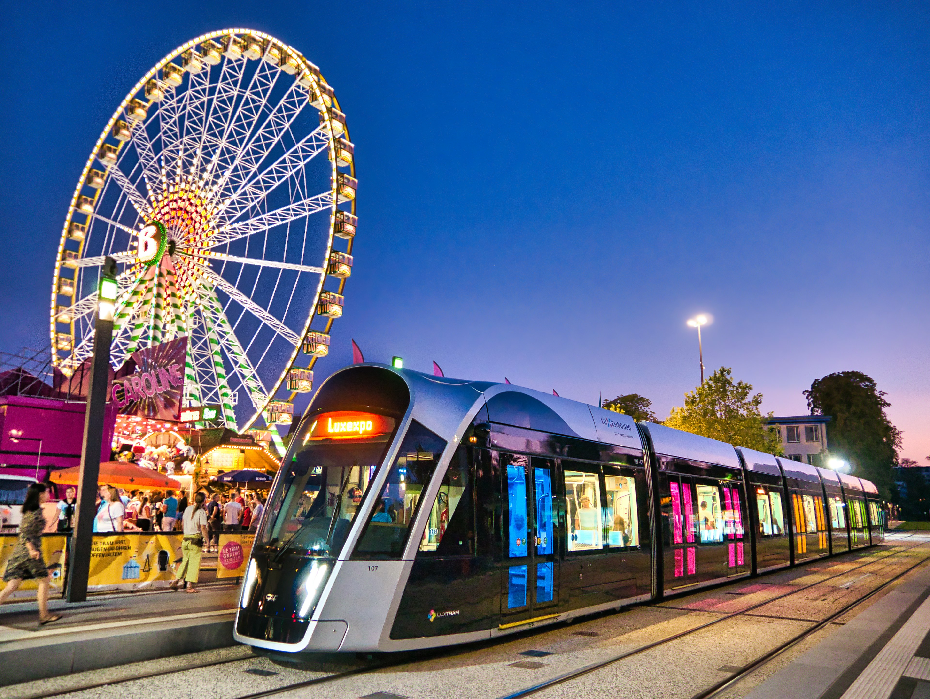 View on Schueberfouer - annual traditional fair of Luxembourg and a tram passing nearby;