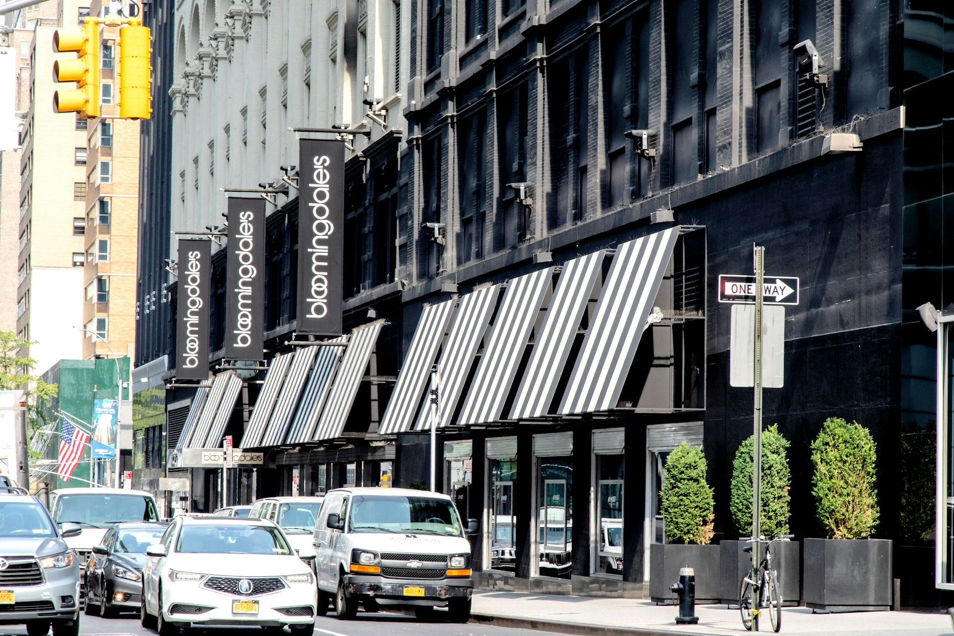 The exterior of a large department store with Bloomingdale's written on its black and white awnings