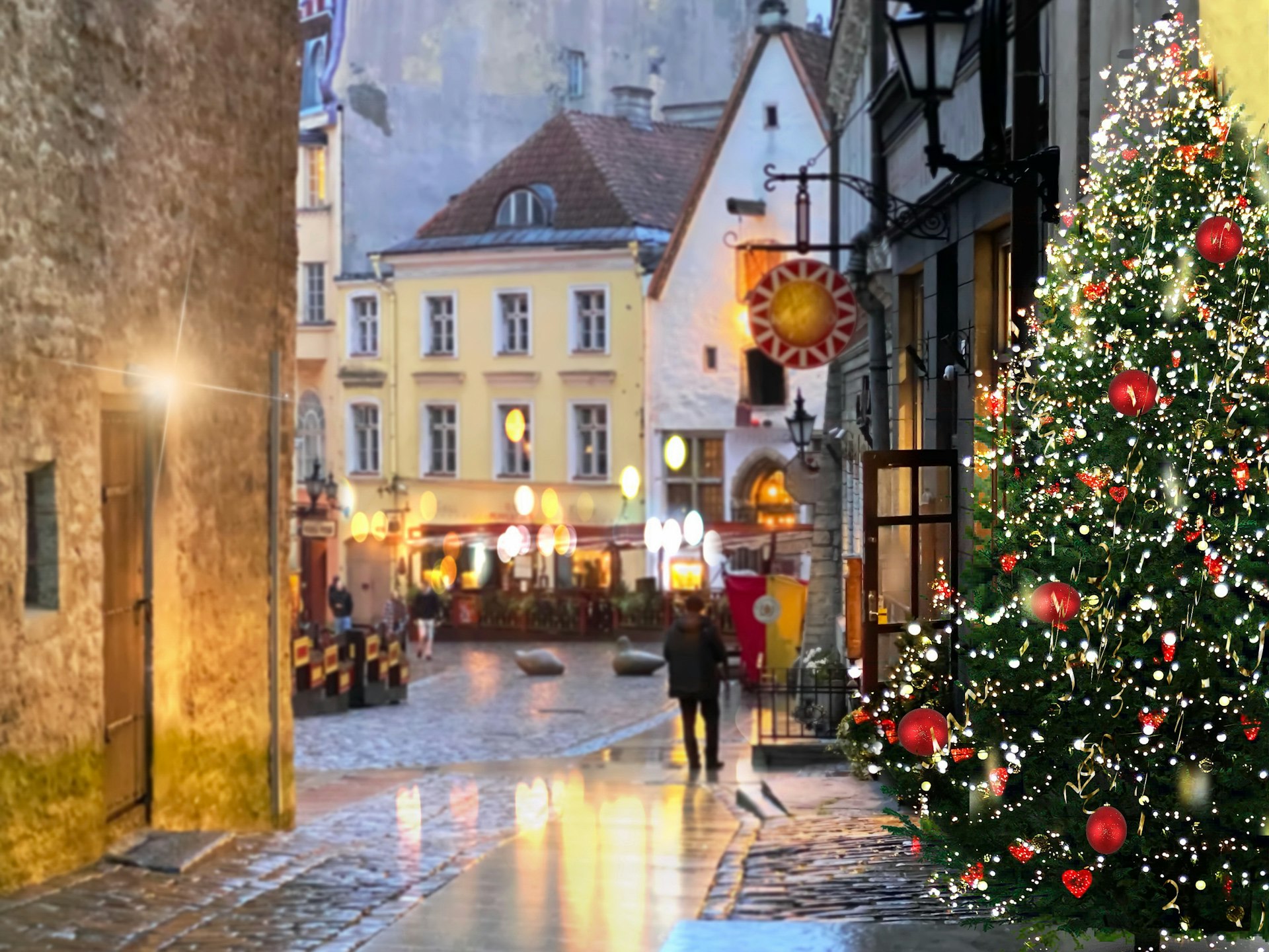 Christmas tree illumination on rainy street people walk blurred evening light reflection on pavement in medieval Tallinn old town holidays in Estonia.,