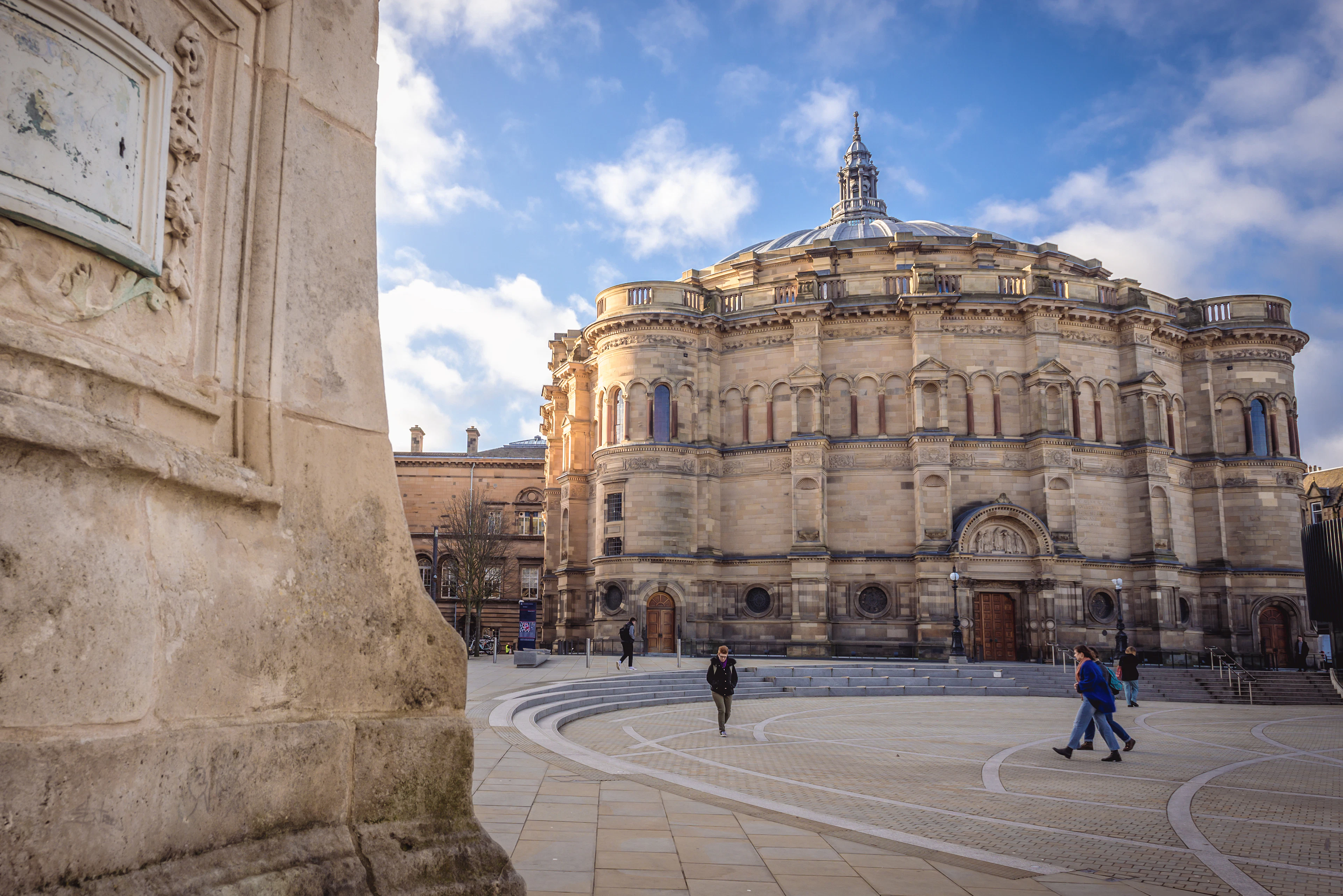 Люди гуляют перед зданием McEwan Hall в Эдинбургском университете