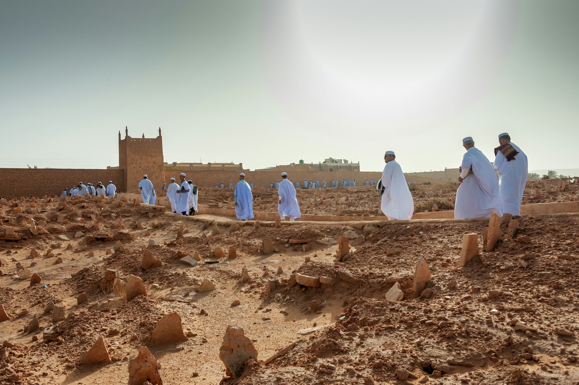 M’zab people in white robes walk toward a mosque, El Guerrara, Ghardaïa, Algeria