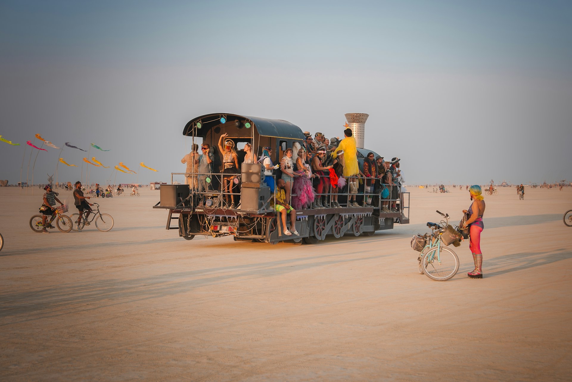 People in a festive vehicles and on bicycles at the Burning Man festival, Black Rock Desert, Nevada, USA
