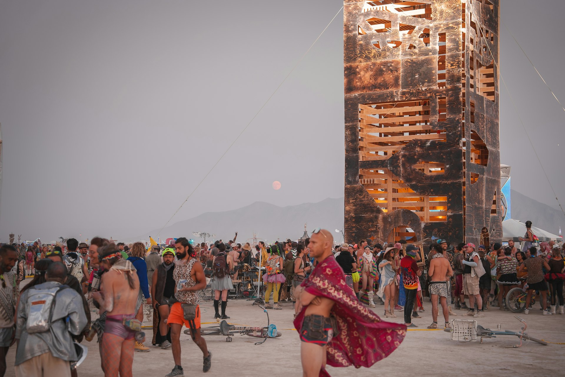 Costumed revelers stand in front of a structure at the Burning Man festival, Black Rock Desert, Nevada, USA