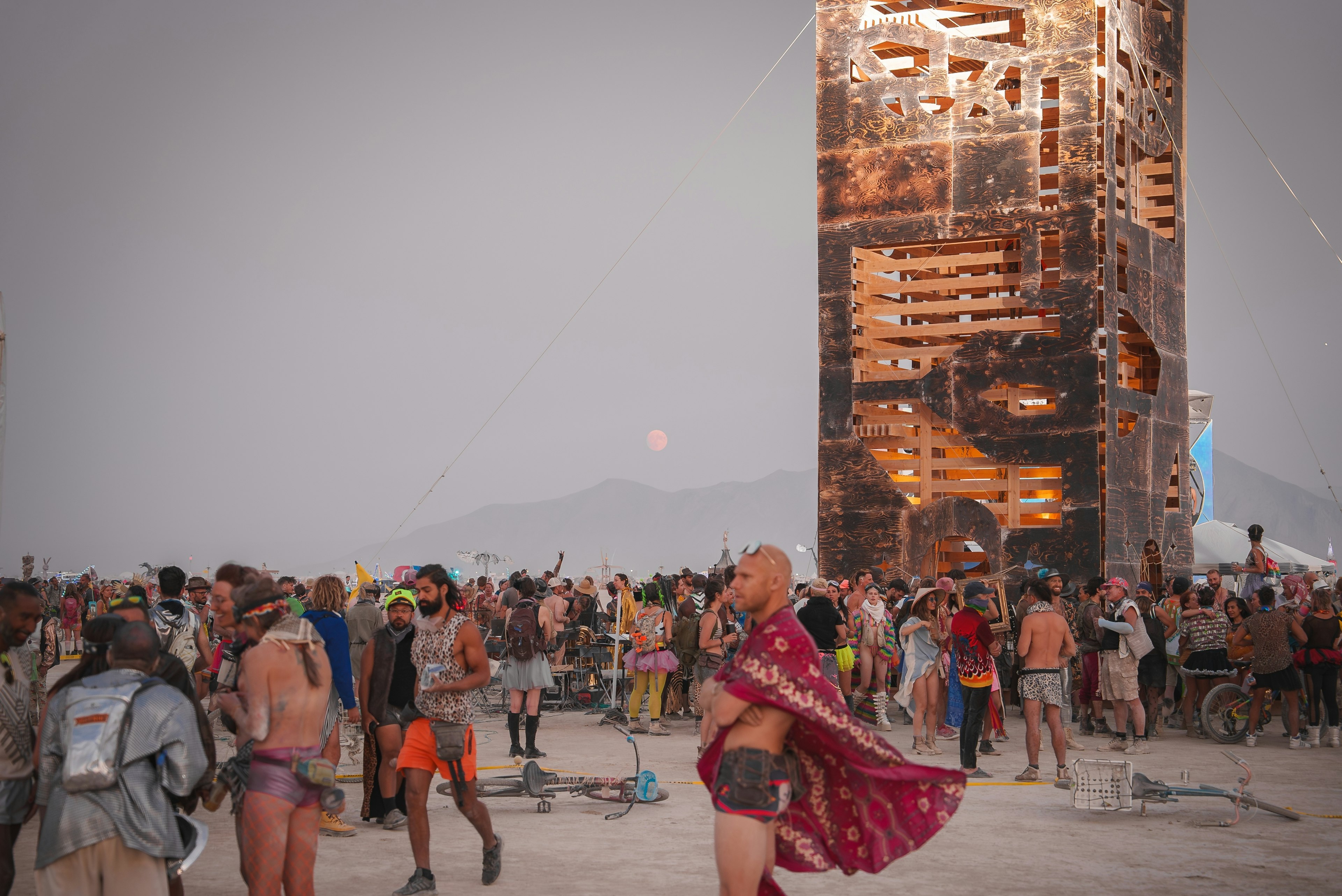 Costumed revelers stand in front of a structure at the Burning Man festival, Black Rock Desert, Nevada, USA