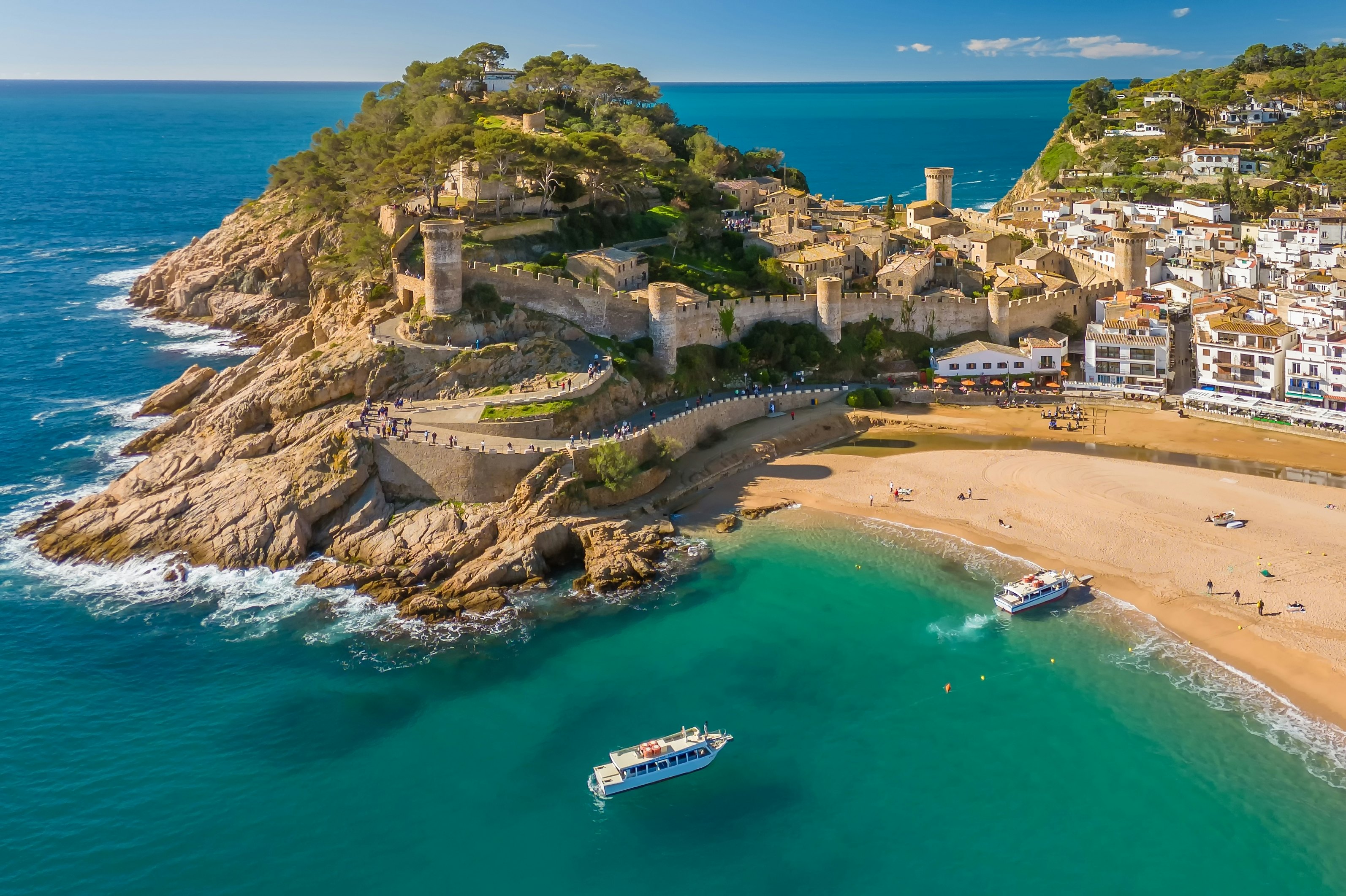 An aerial view of boats approaching the beach at Tossa de Mar, Costa Brava, Catalonia, Spain