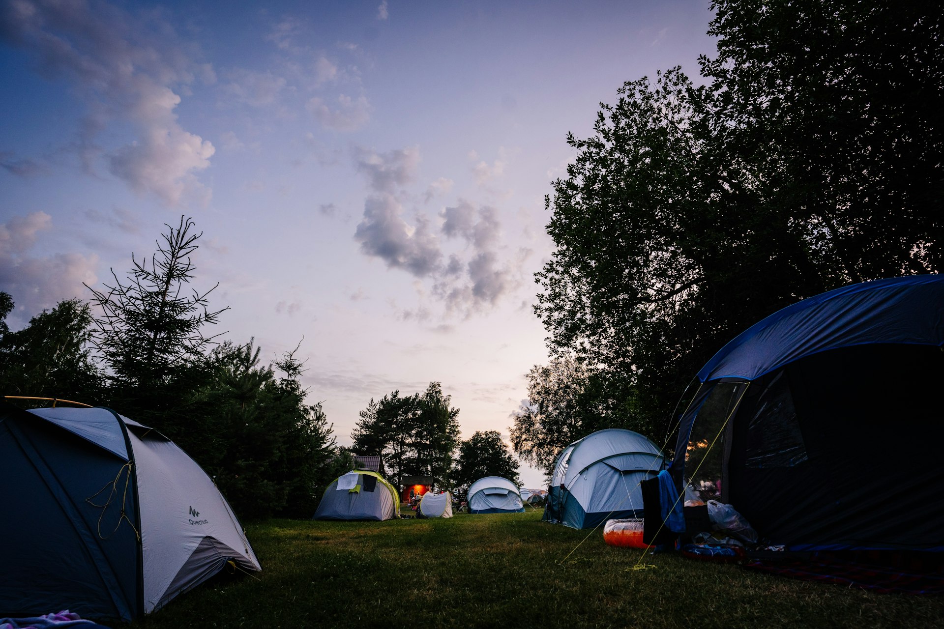 Tents pitched at a campsite as darkness falls