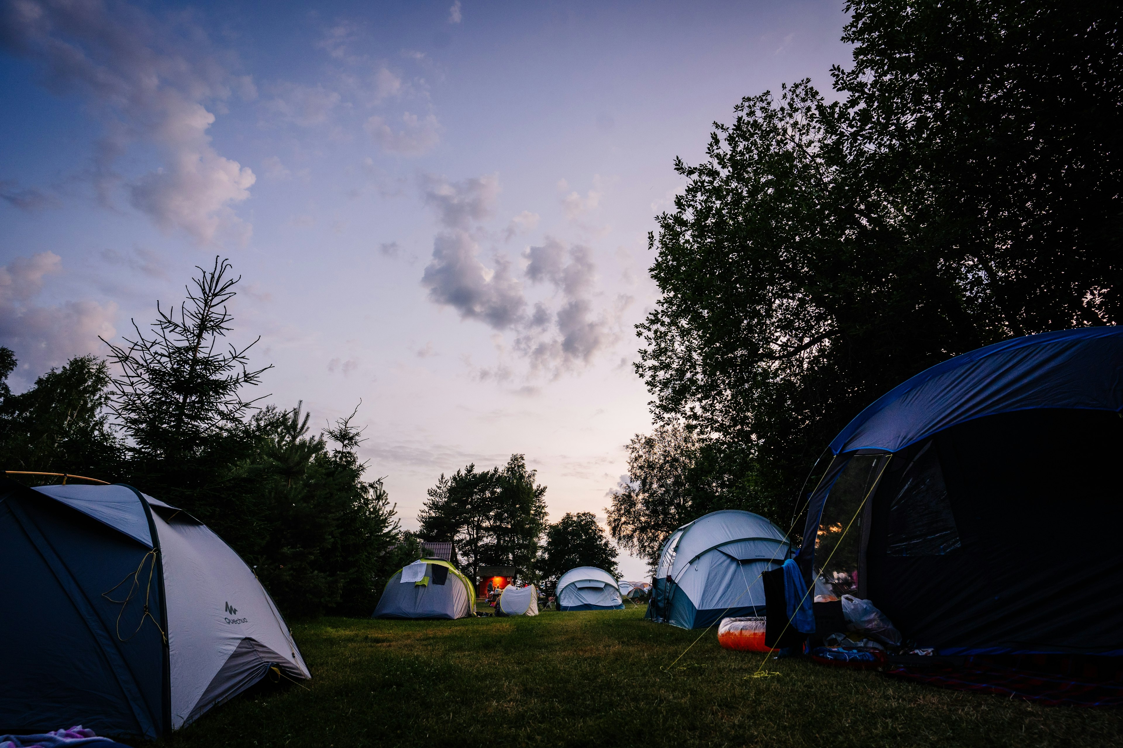 Tents pitched at a campsite as darkness falls