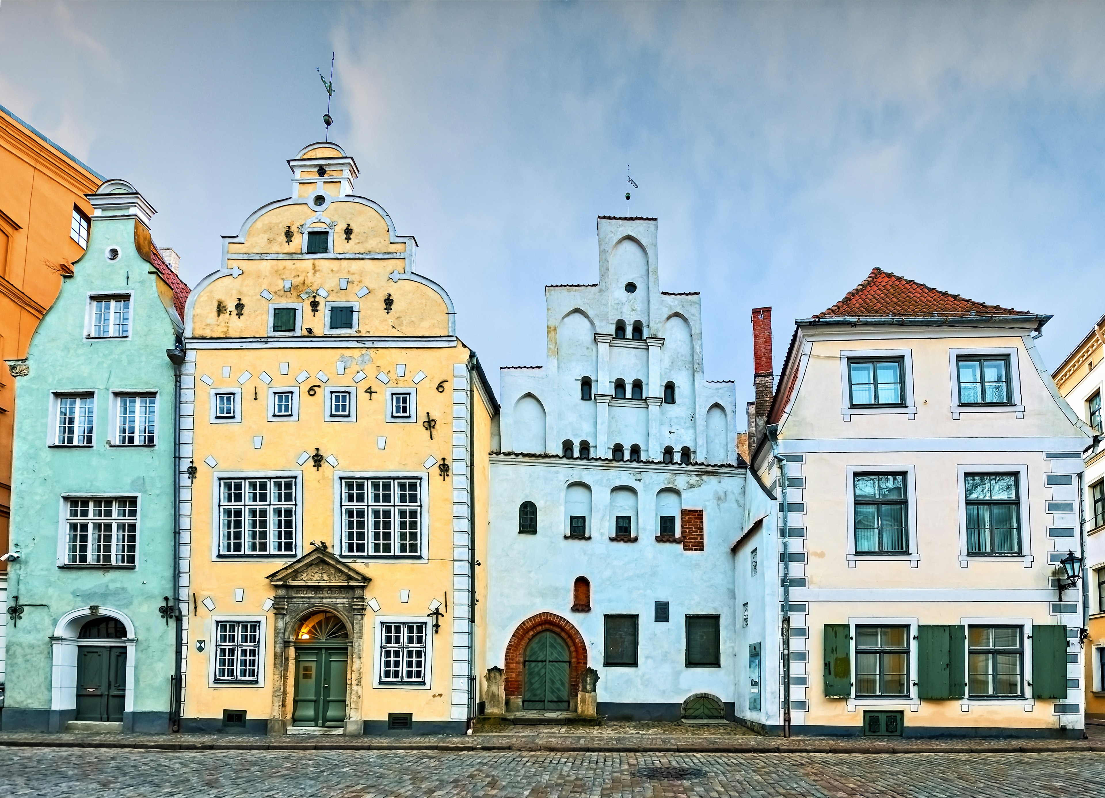 A row of pastel-colored medieval buildings at the edge of a city square