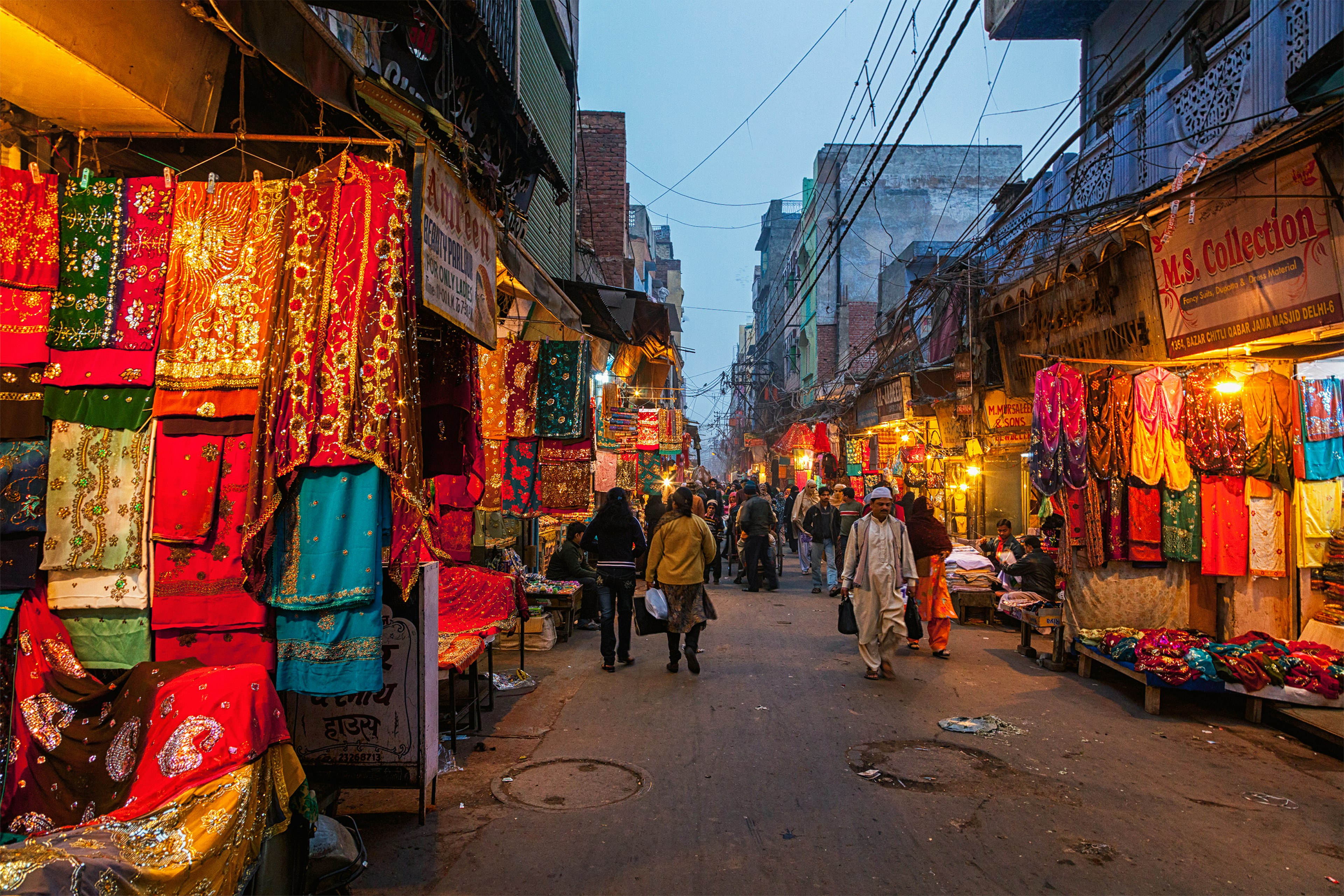 People on Chitli Qabar Bazar market street in New Delhi during the evening.