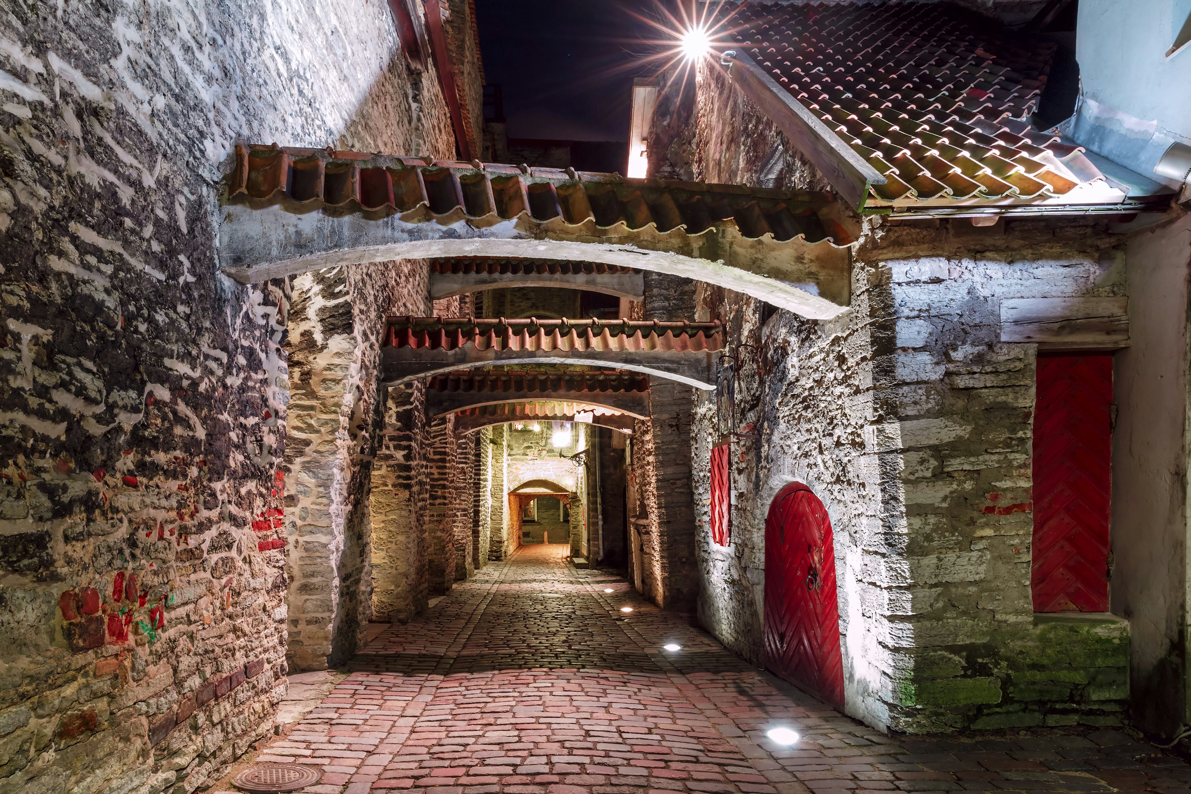 Medieval street St. Catherine's Passage or Katariina kaik, half-hidden walkway in Old Town at night, Tallinn, Estonia