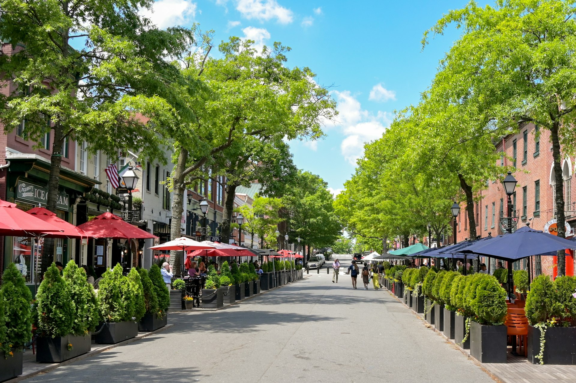 People dining at outdoor tables outside restaurants on King Street, which is the town's main street.