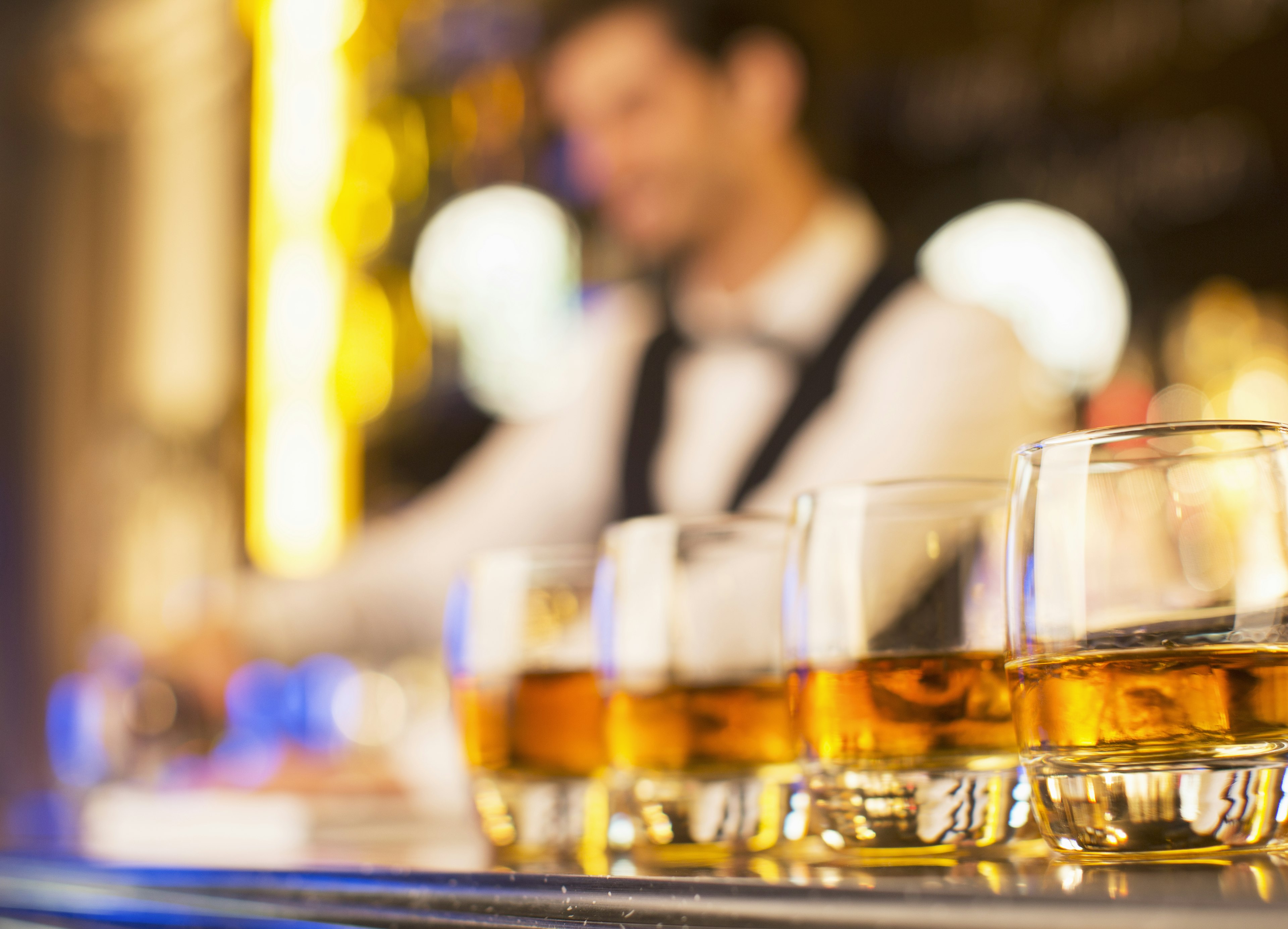 Close-up of bourbon in glasses in a row on bar