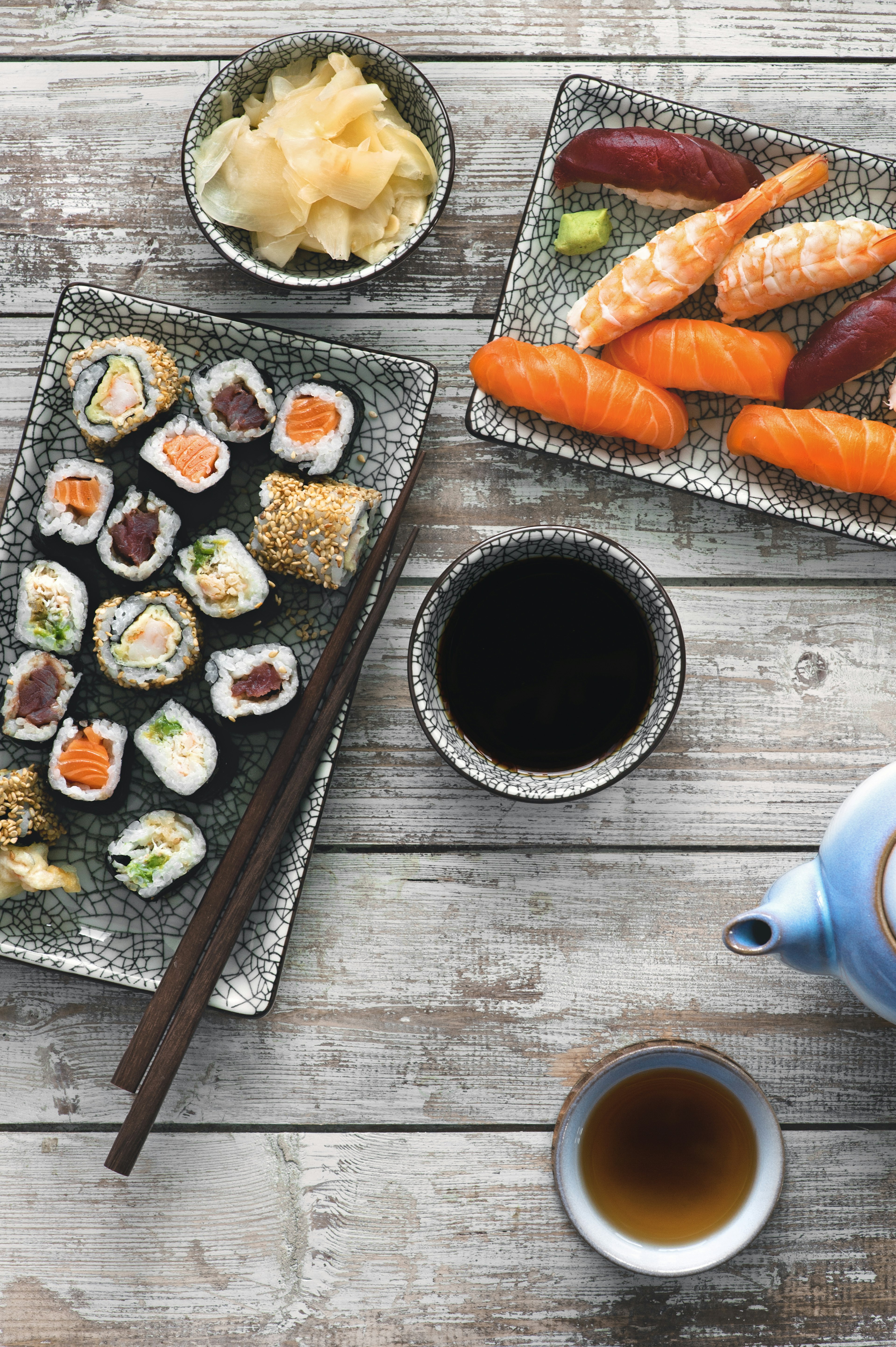 A shot of impeccably prepared Japanese dishes, including fish, sushi, cabbage, soup and tea