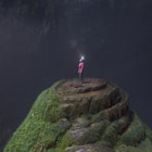 A woman gazes up to a hole in the ceiling of Hang Son Doong cave