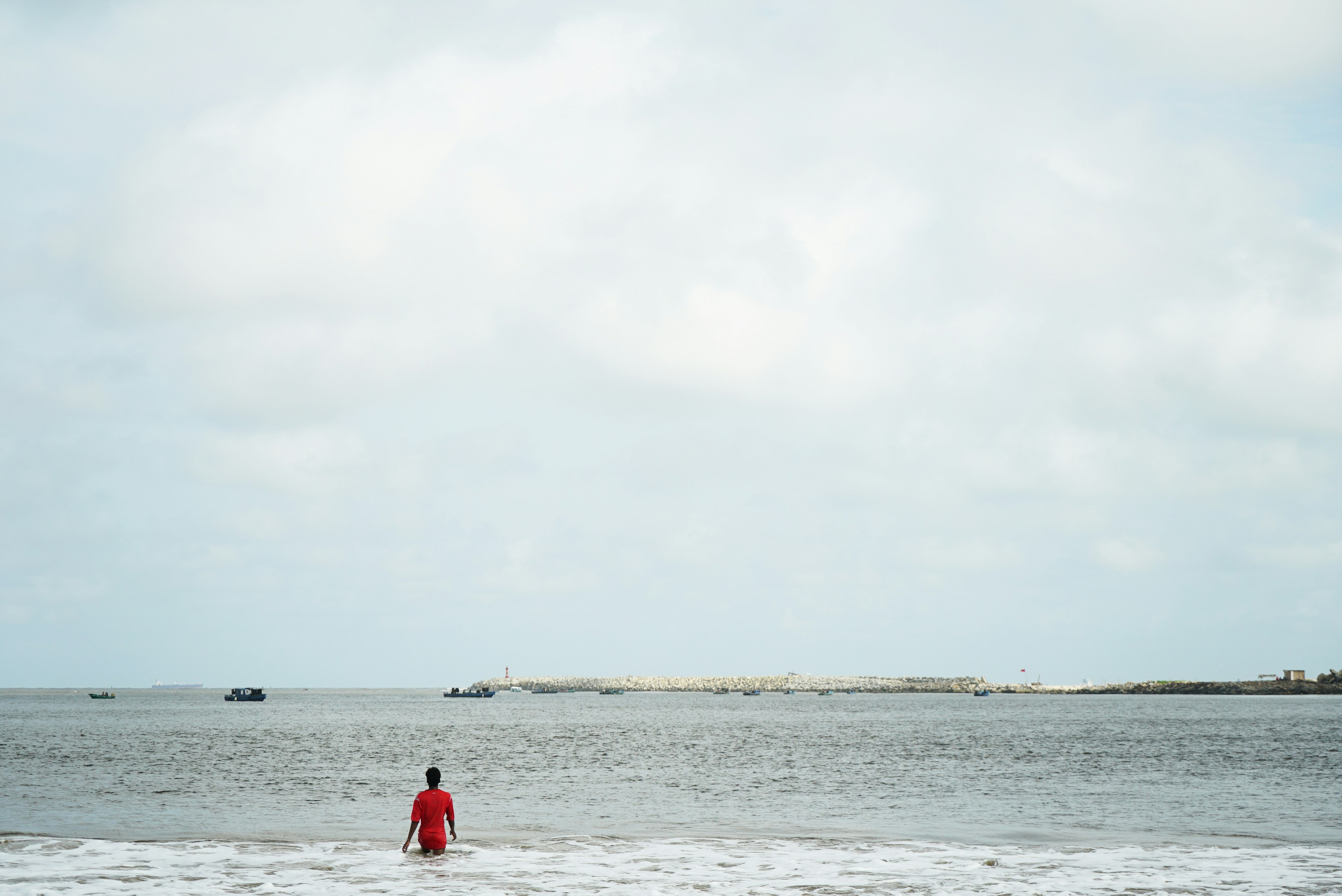 A single figure wades out into the water near Tarkwa Bay in Lagos