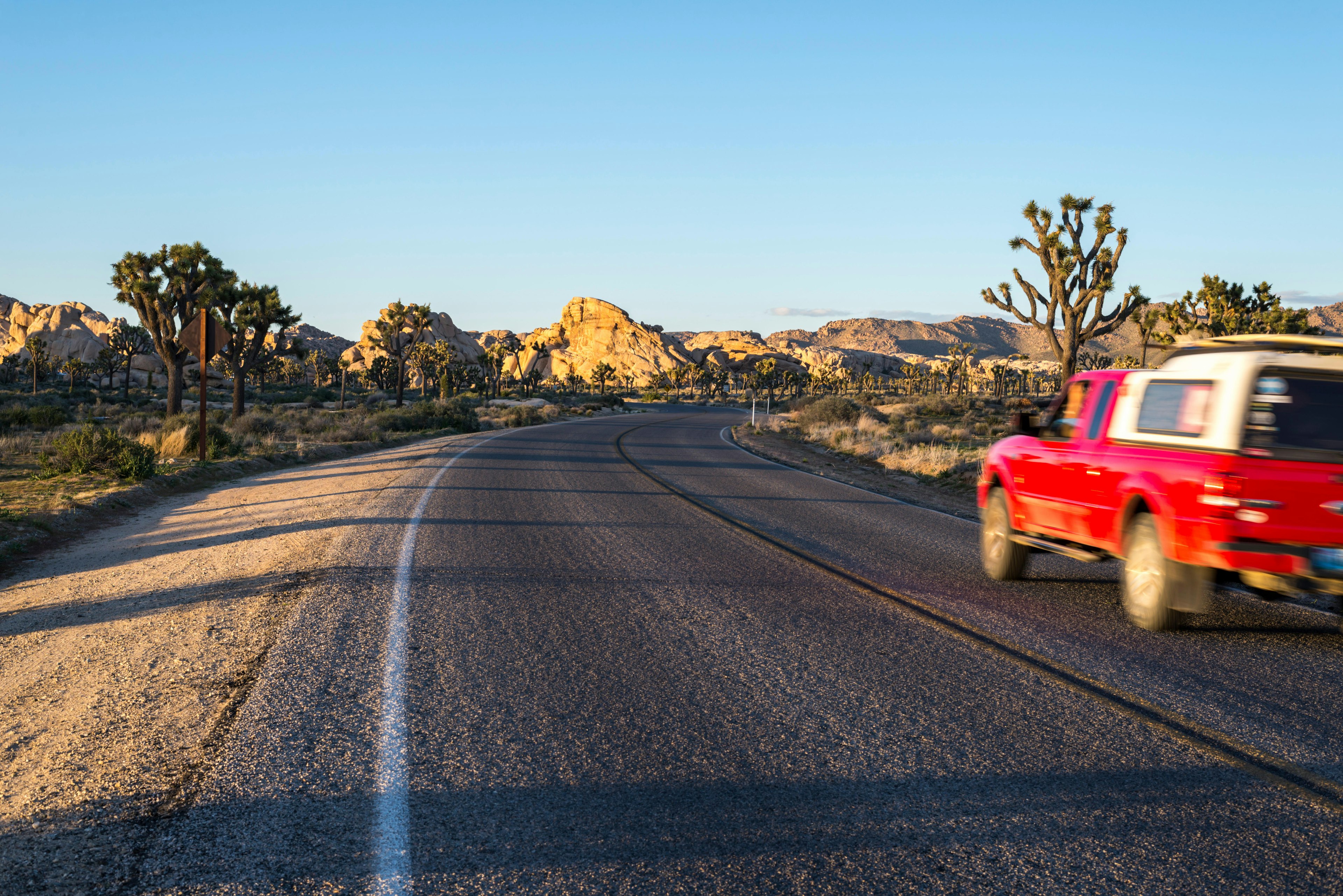 Car on road running through Joshua Tree National Park, California, USA.