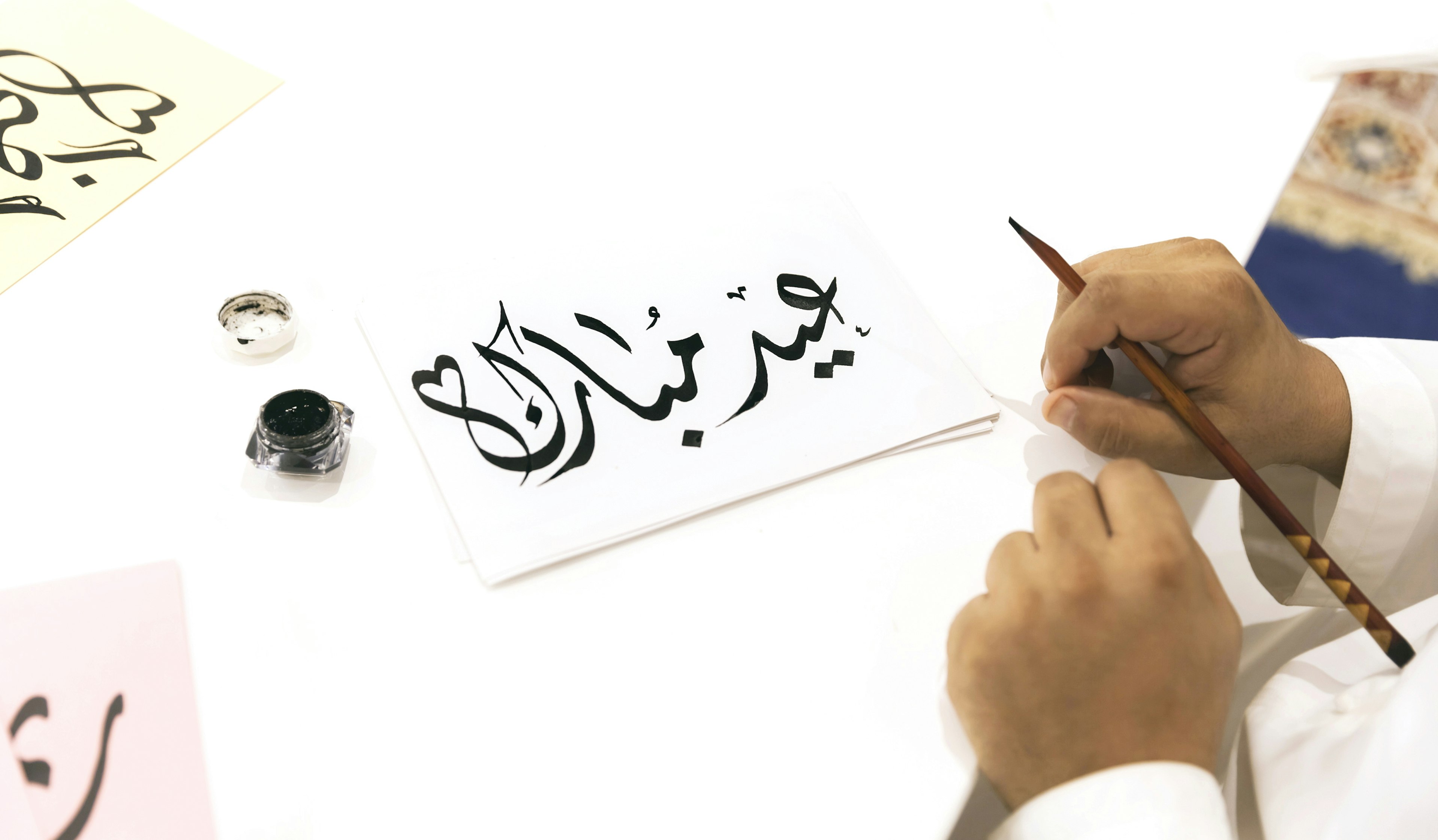 Human Hand Holding Pen By Paper On Table