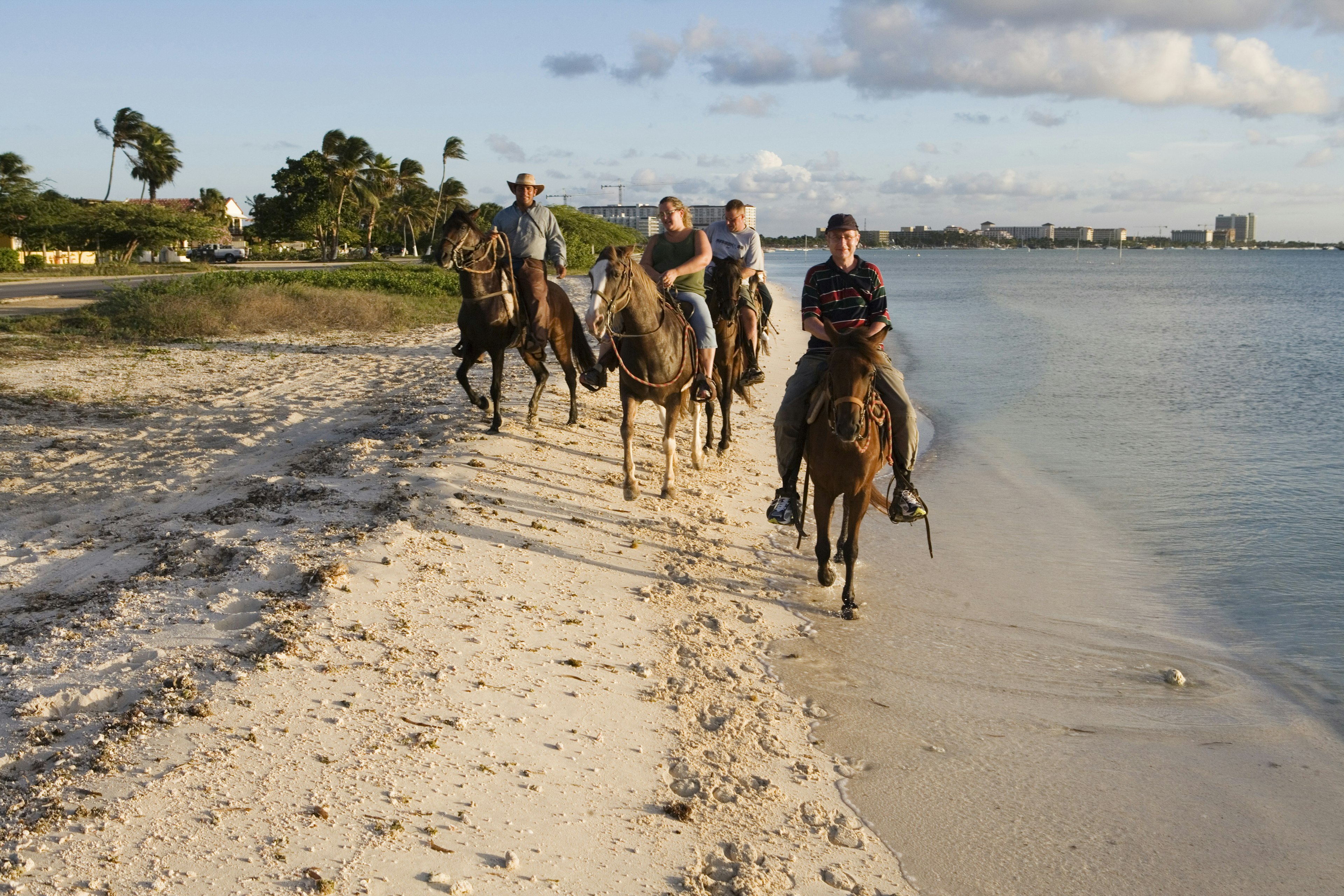 People riding horses on the beach in Aruba