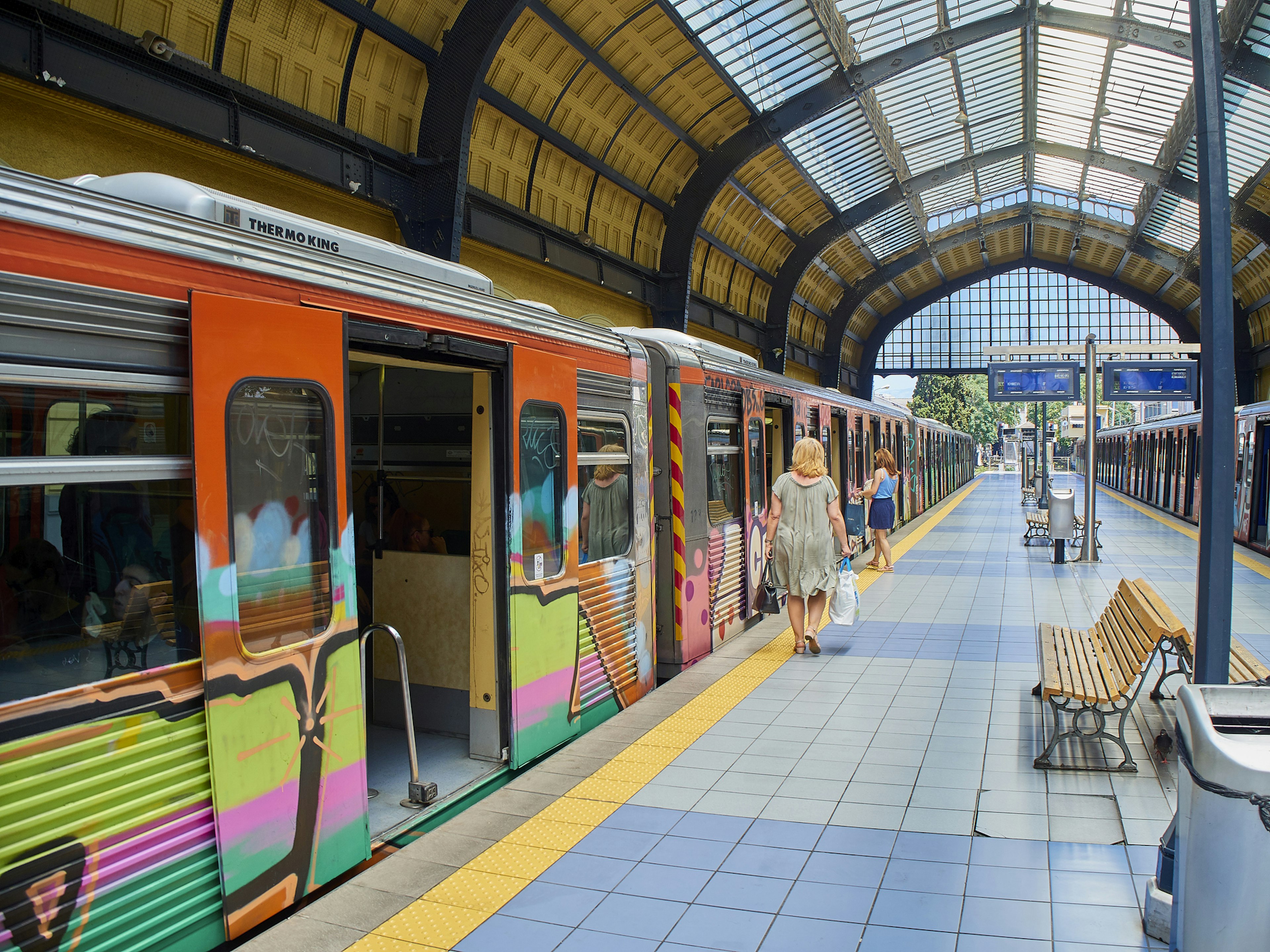 Two female passengers entering a train at Piraeus Metro station. Athens, Greece.