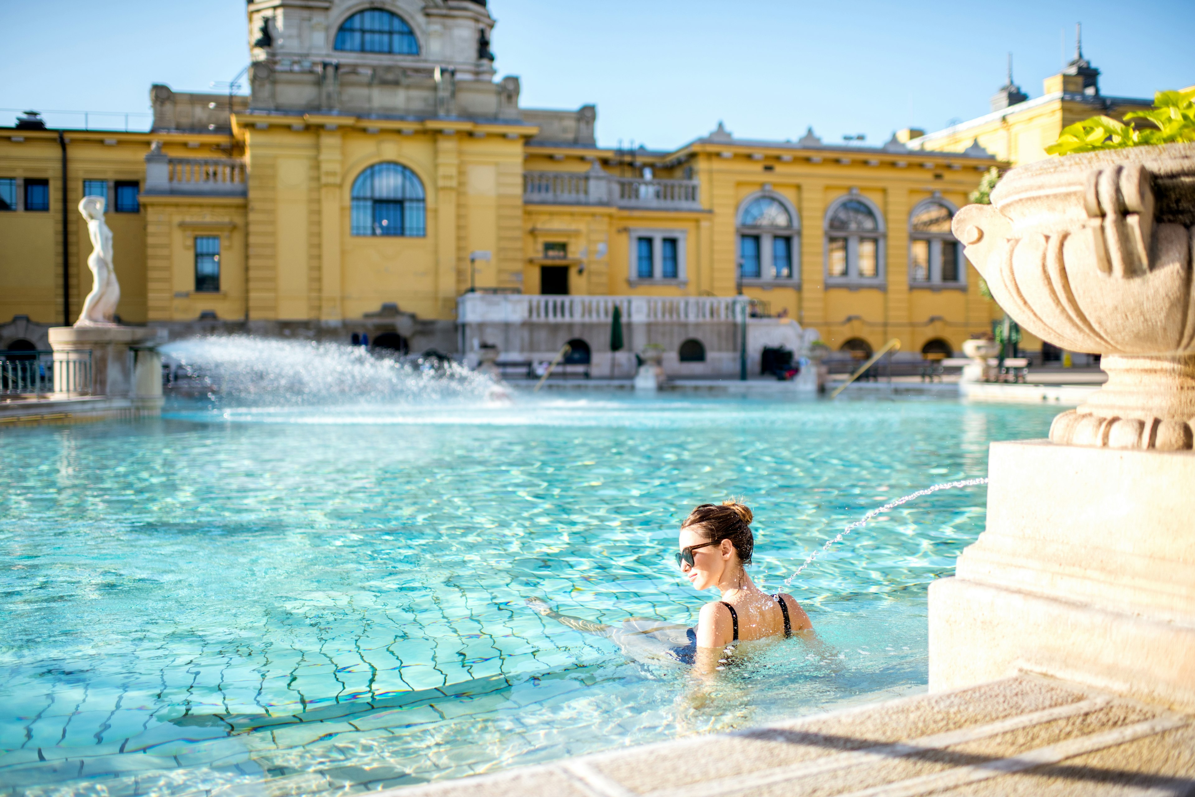 A woman bathing outdoors in the sunshine at the Szechenyi Baths, Budapest