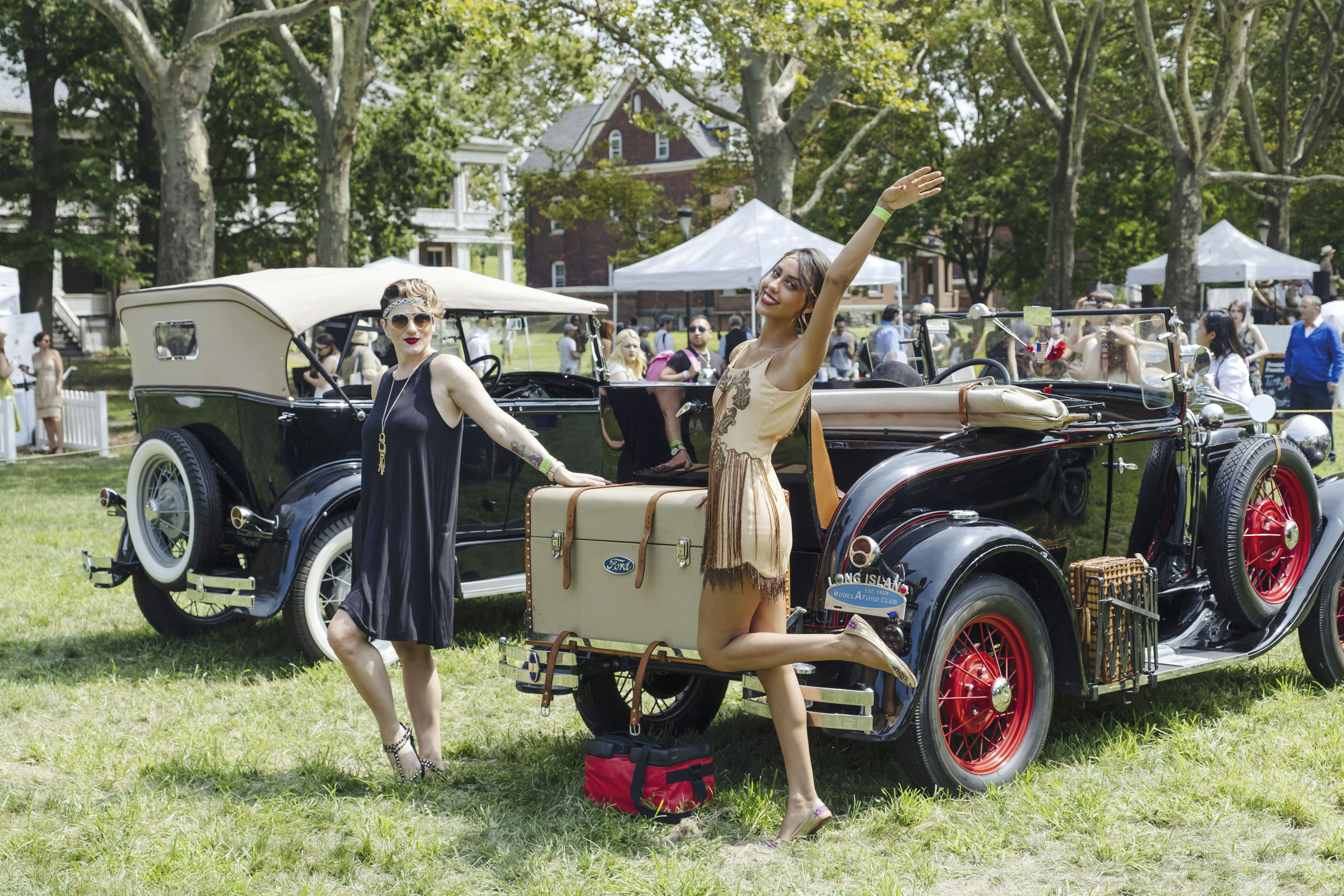 Two women pose by a car at The Jazz Age Lawn Party on Governors Island