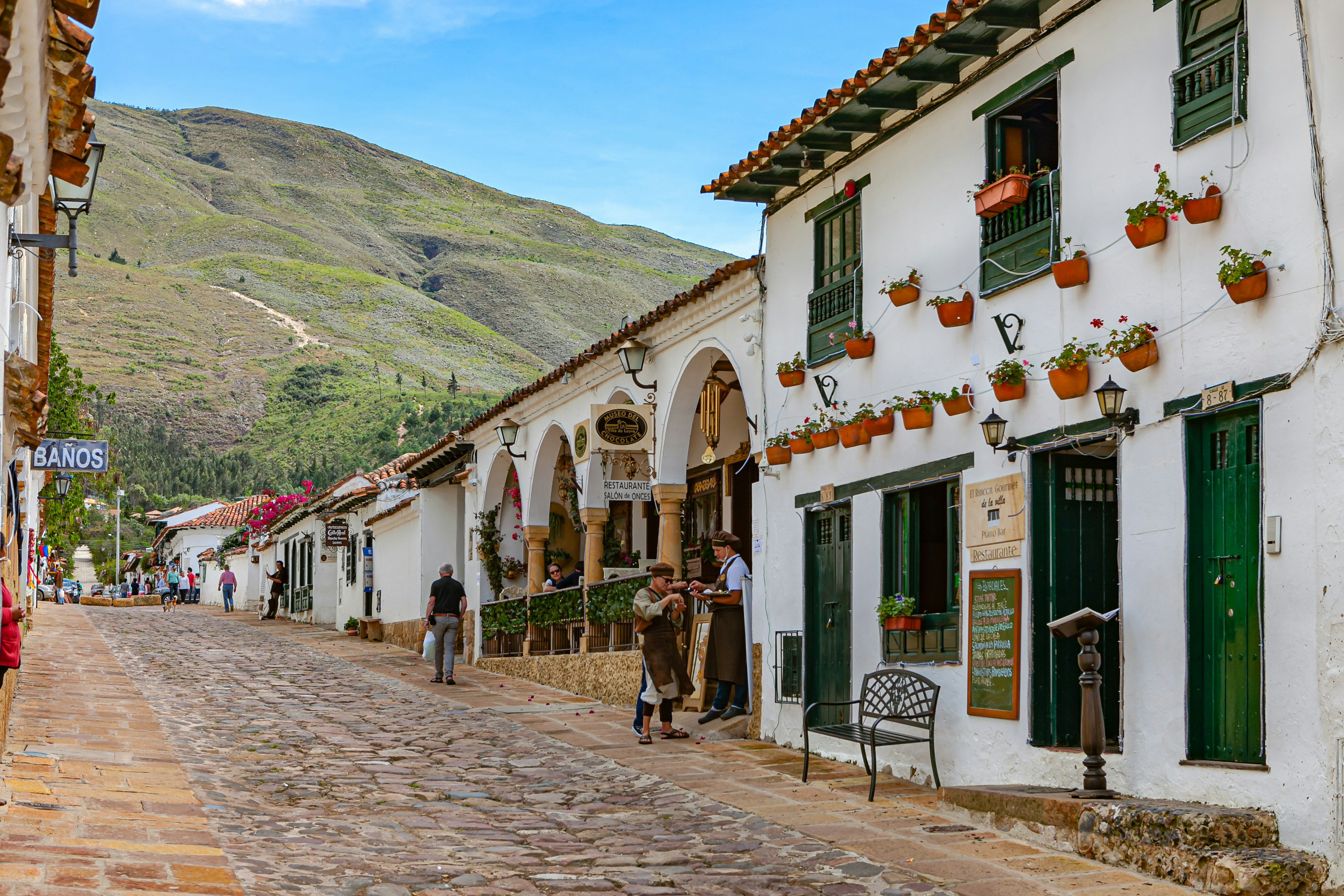 A historic cobbled street lined with white houses