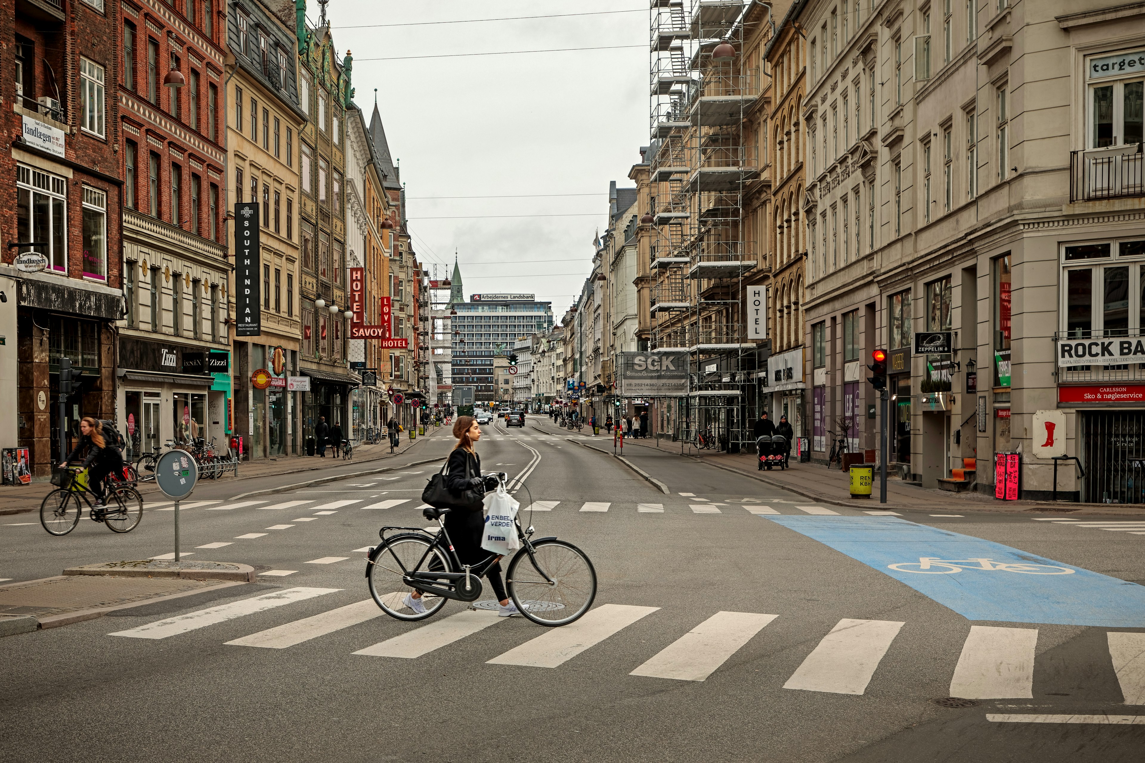 A woman pushing a bicycle along Vesterbrogade in Copenhagen