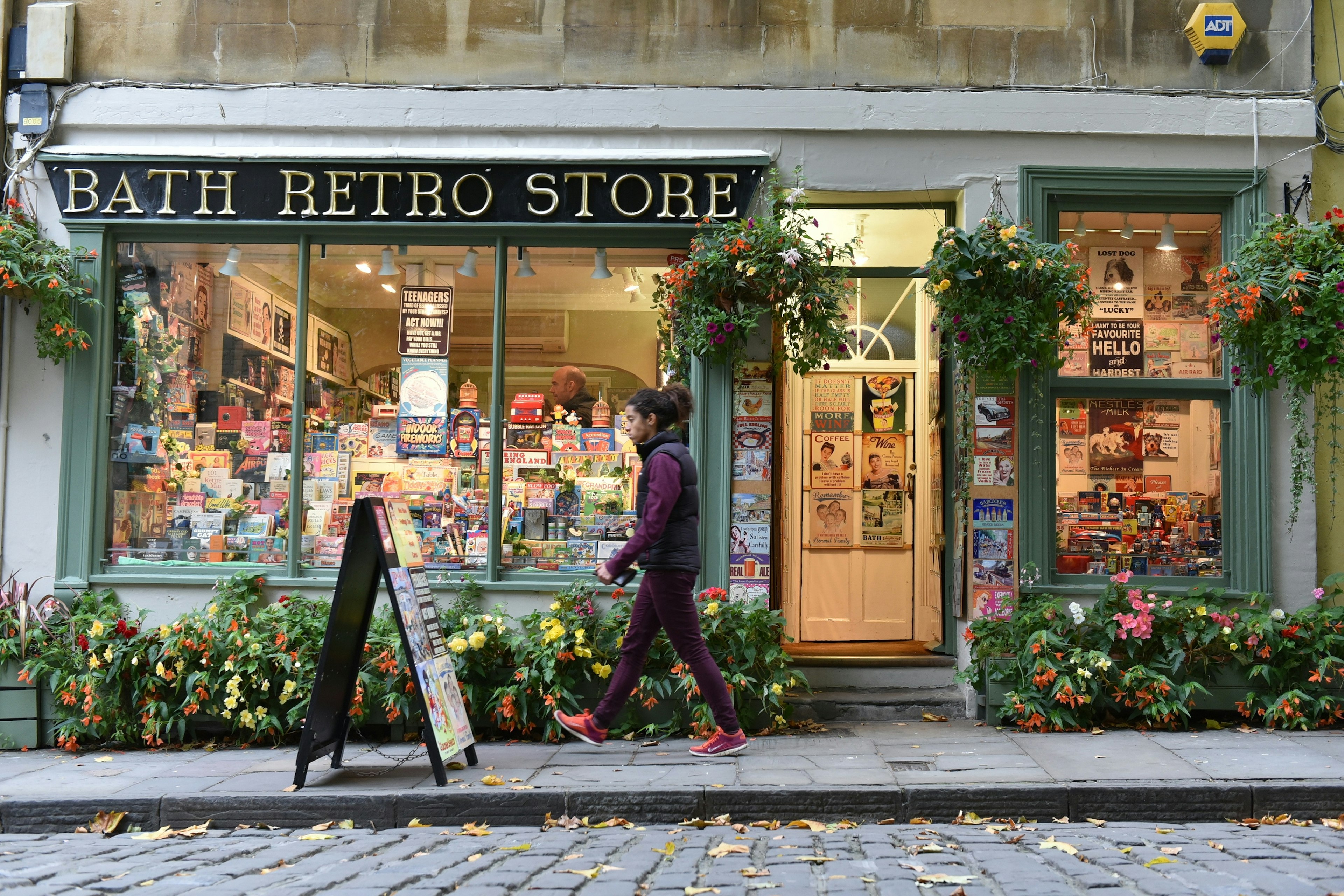 A man passes the front of an independent store with a window full of gifts and souvenirs