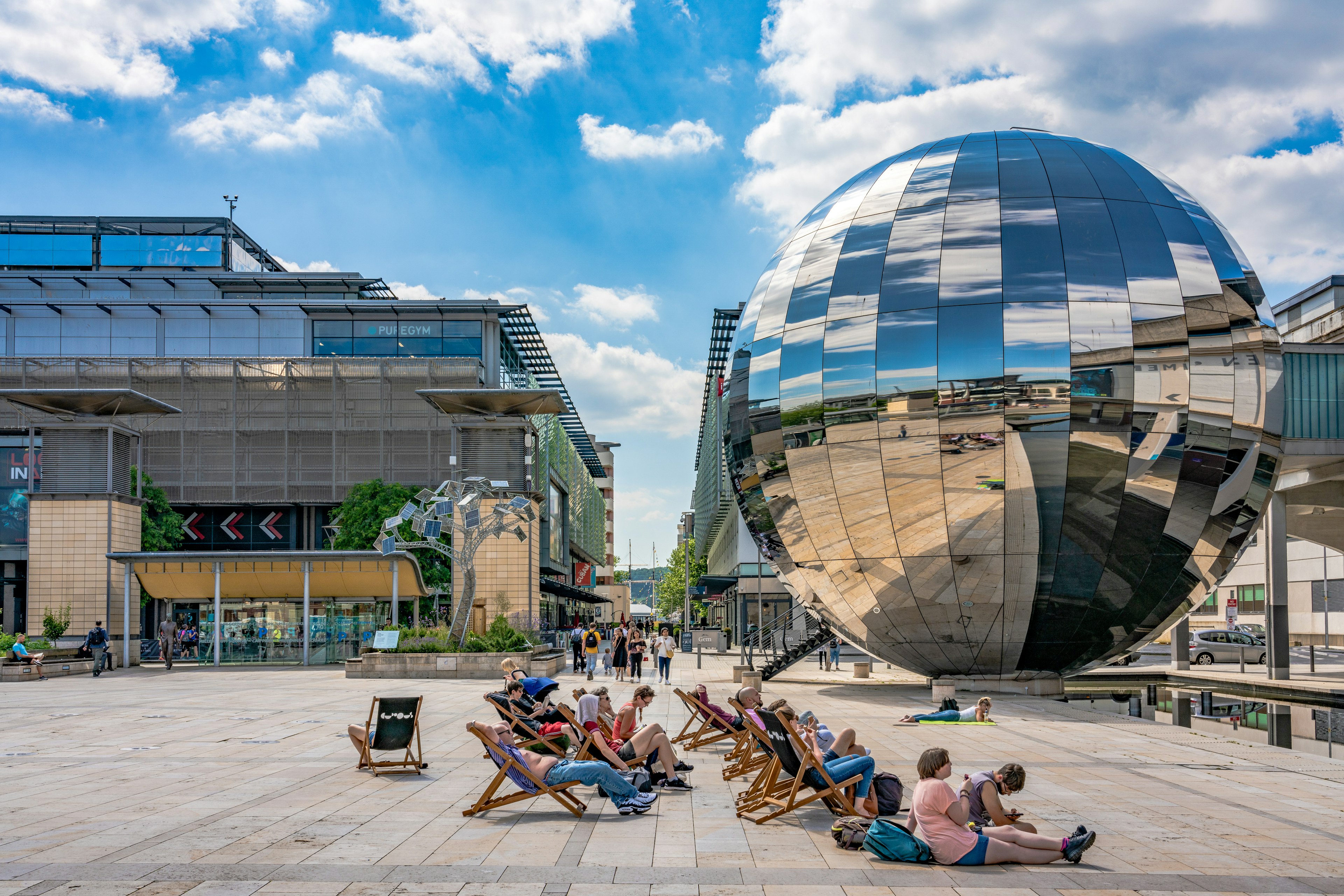 People sit in front of a large disco-ball-like sculpture at the We The Curious Museum in  Bristol