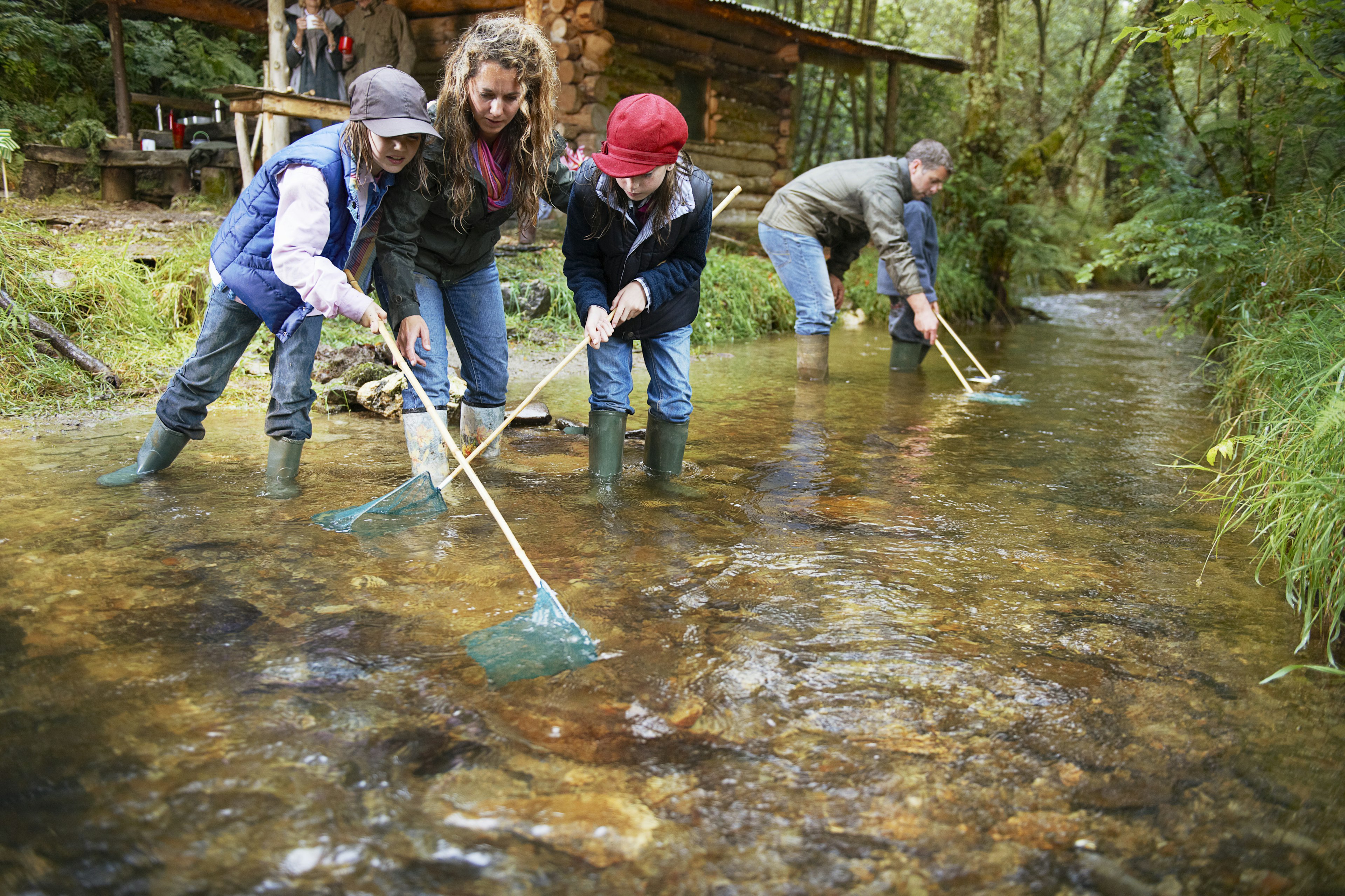 Family fishing with nets in a river