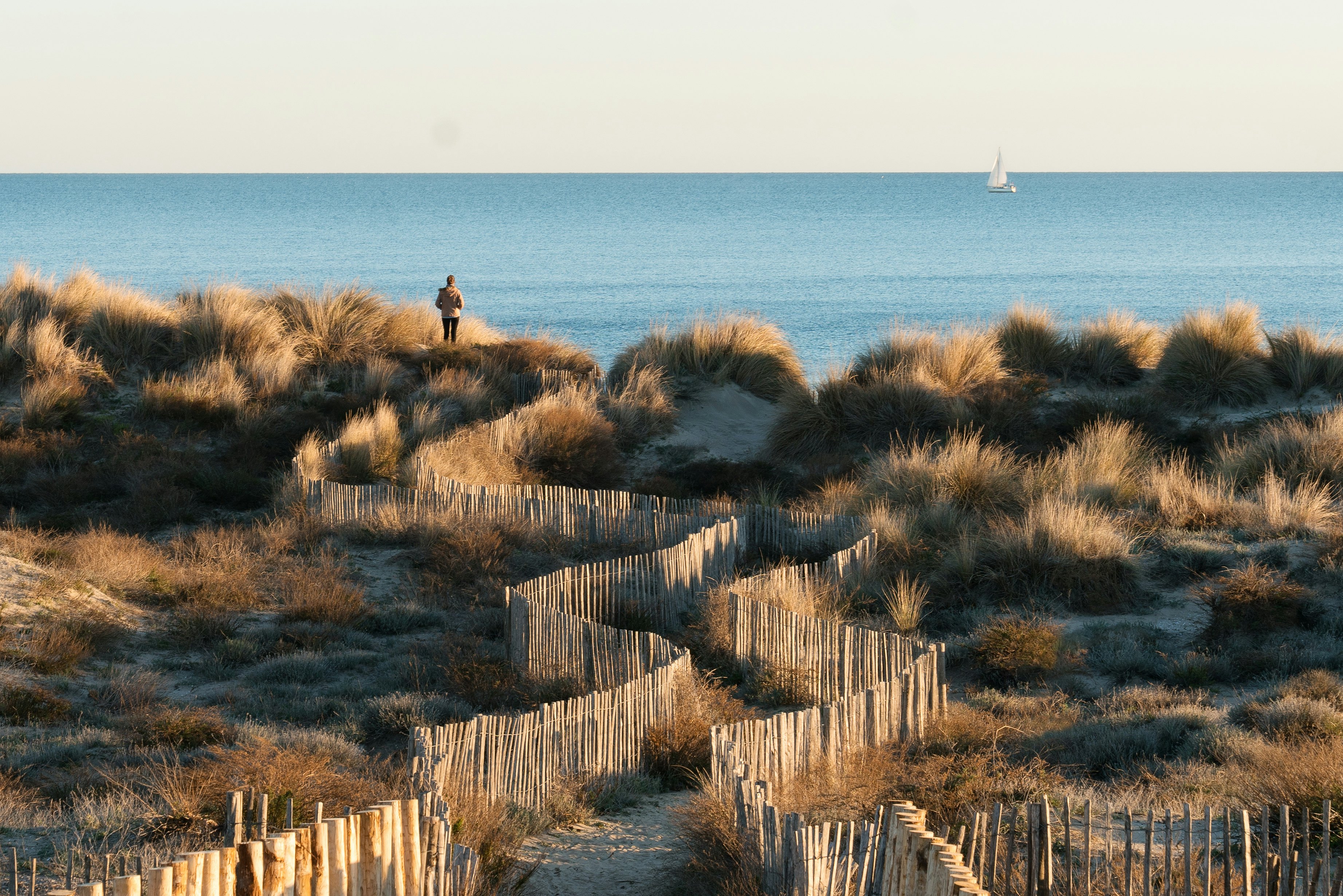 A pathway leads through dunes to the plage du petit Travers