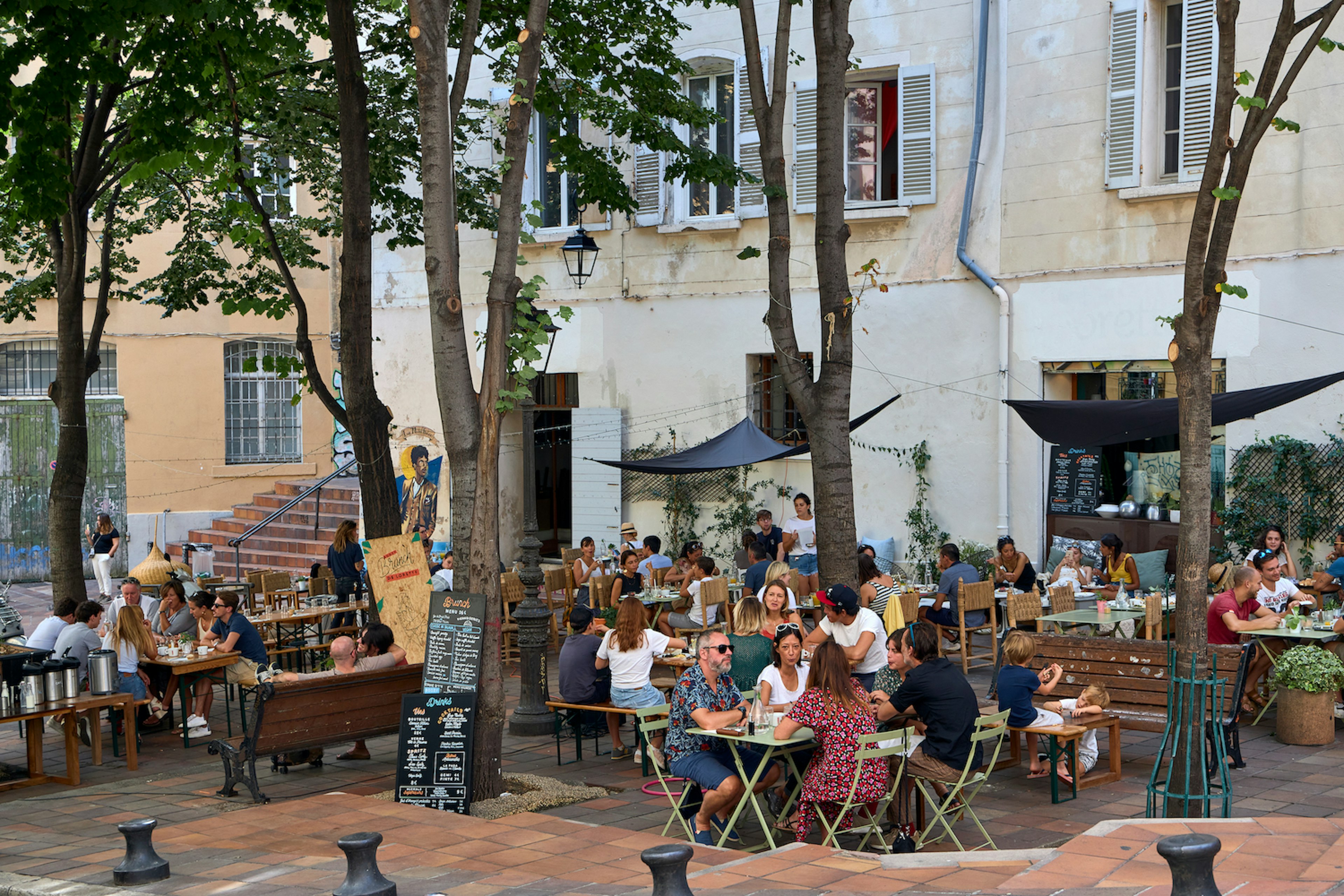 People sitting on outdoor restaurant terraces in Marseille, Bouches-du-Rhône, France