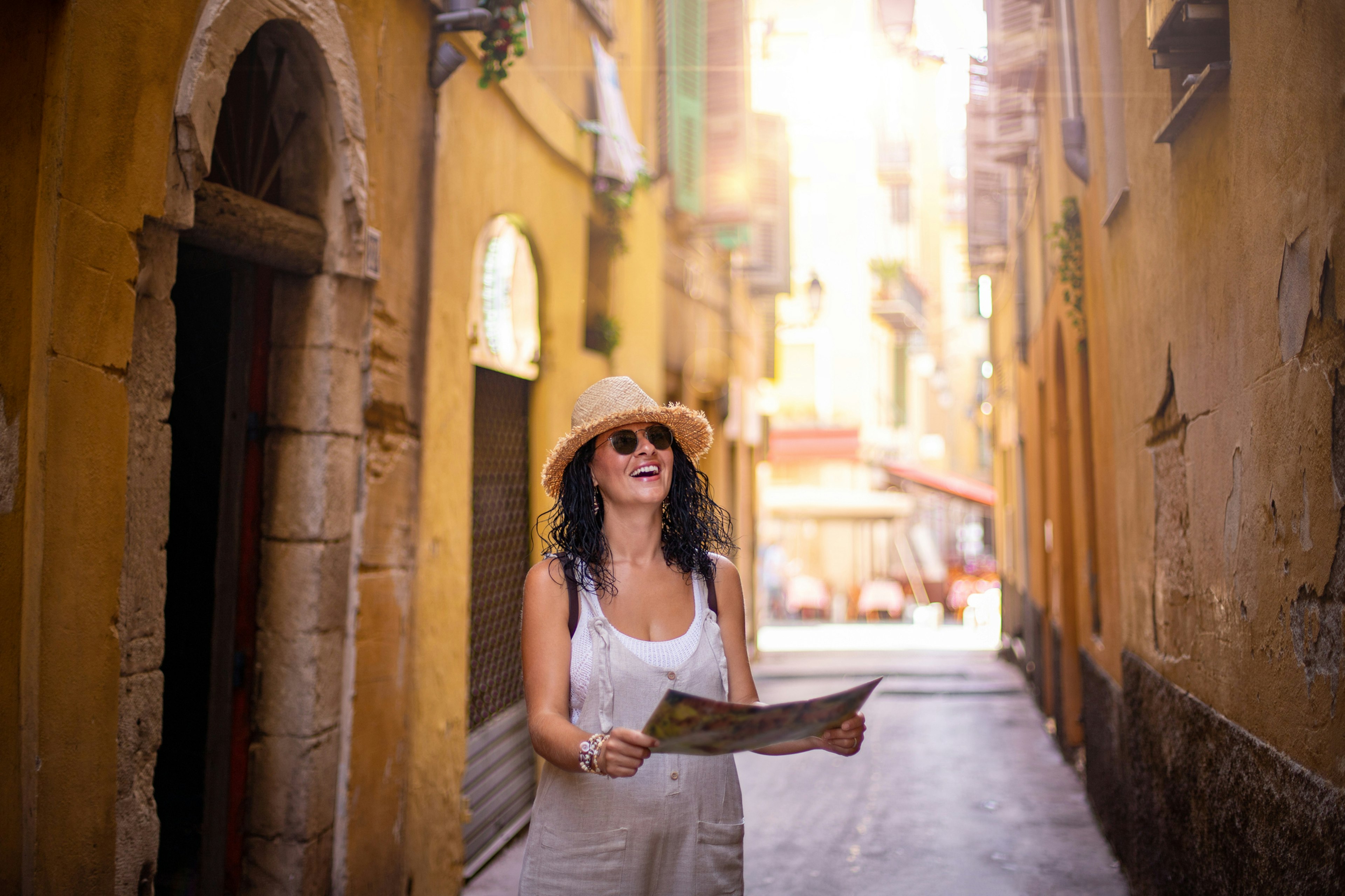 A woman walking along a narrow street in the old town of Nice in France.