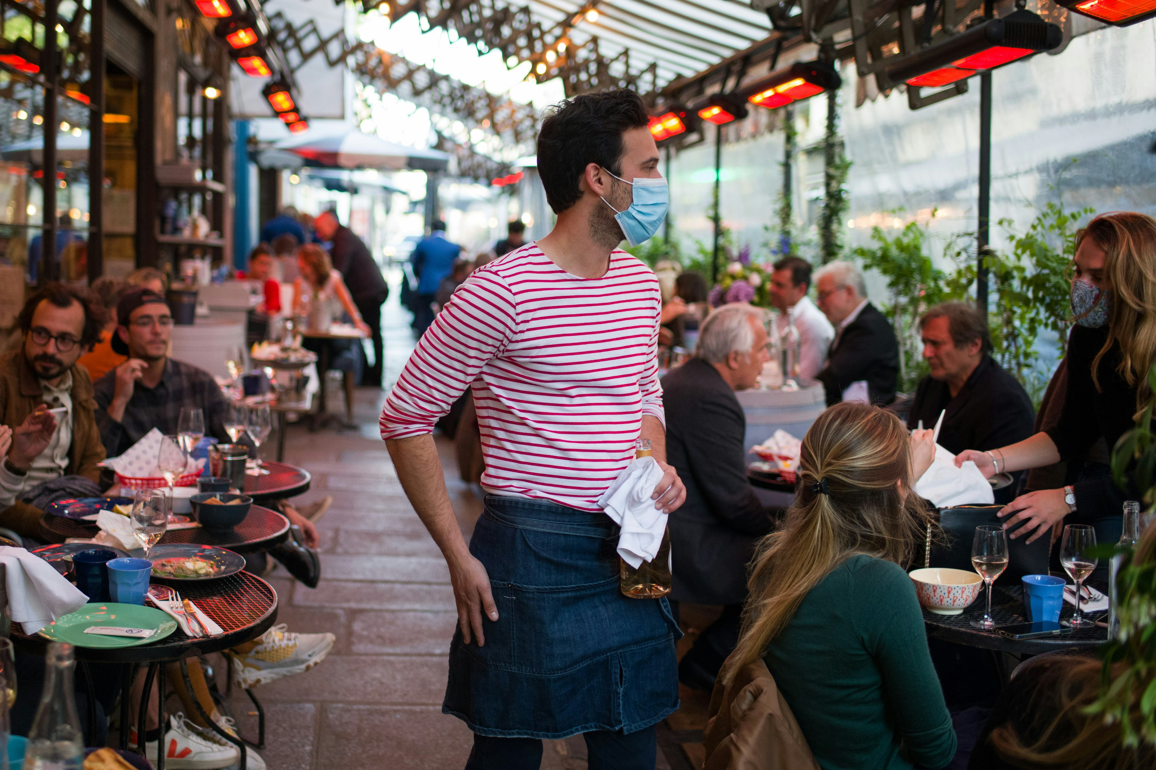 A waiter in a mask in a Parisian cafe