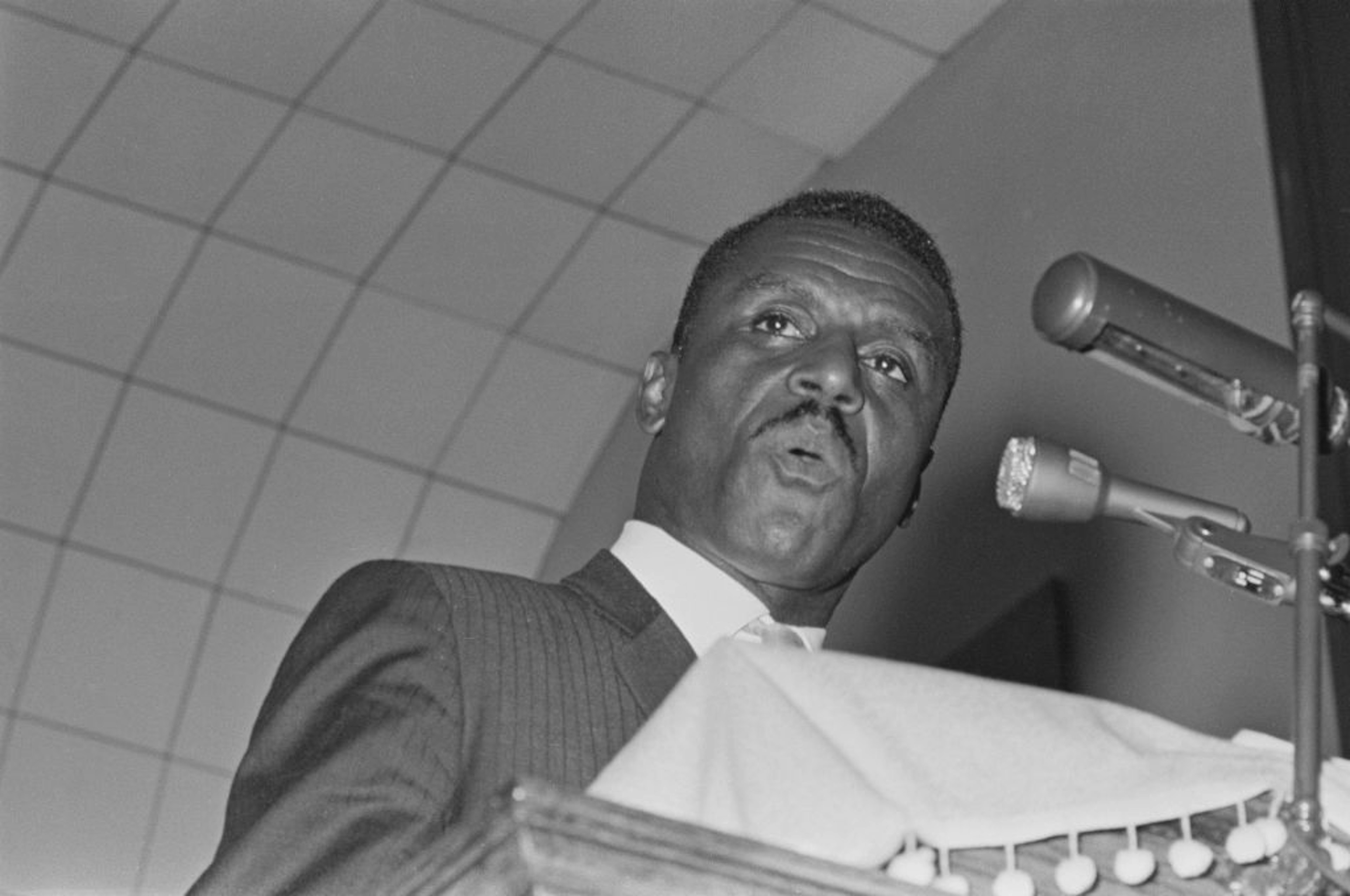 A black man speaking at a lectern