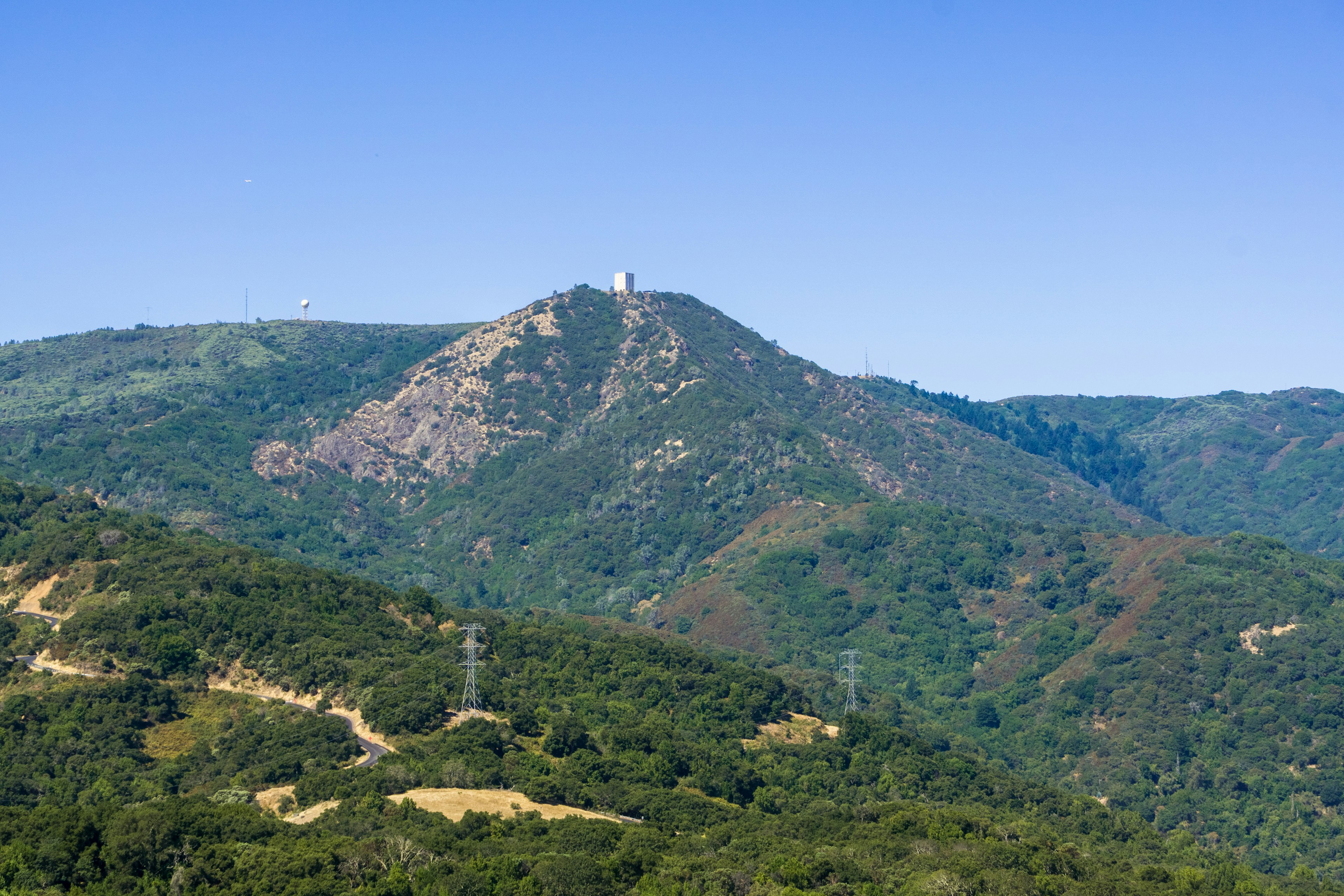 A view towards a huge domed mountain with a small white building on top