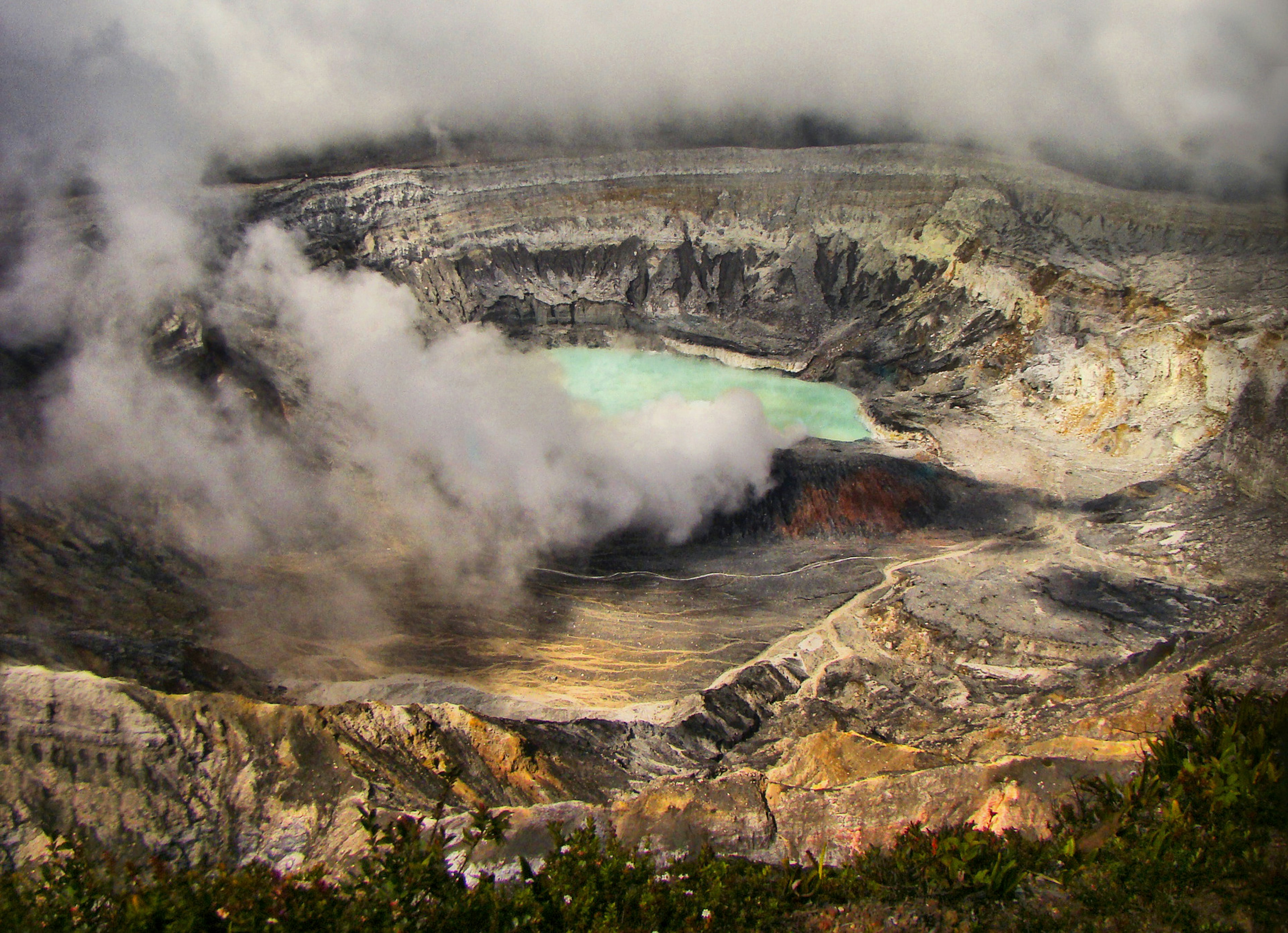 The blue crater lake with steam from the active volcano at Parque Nacional Volcán Poás