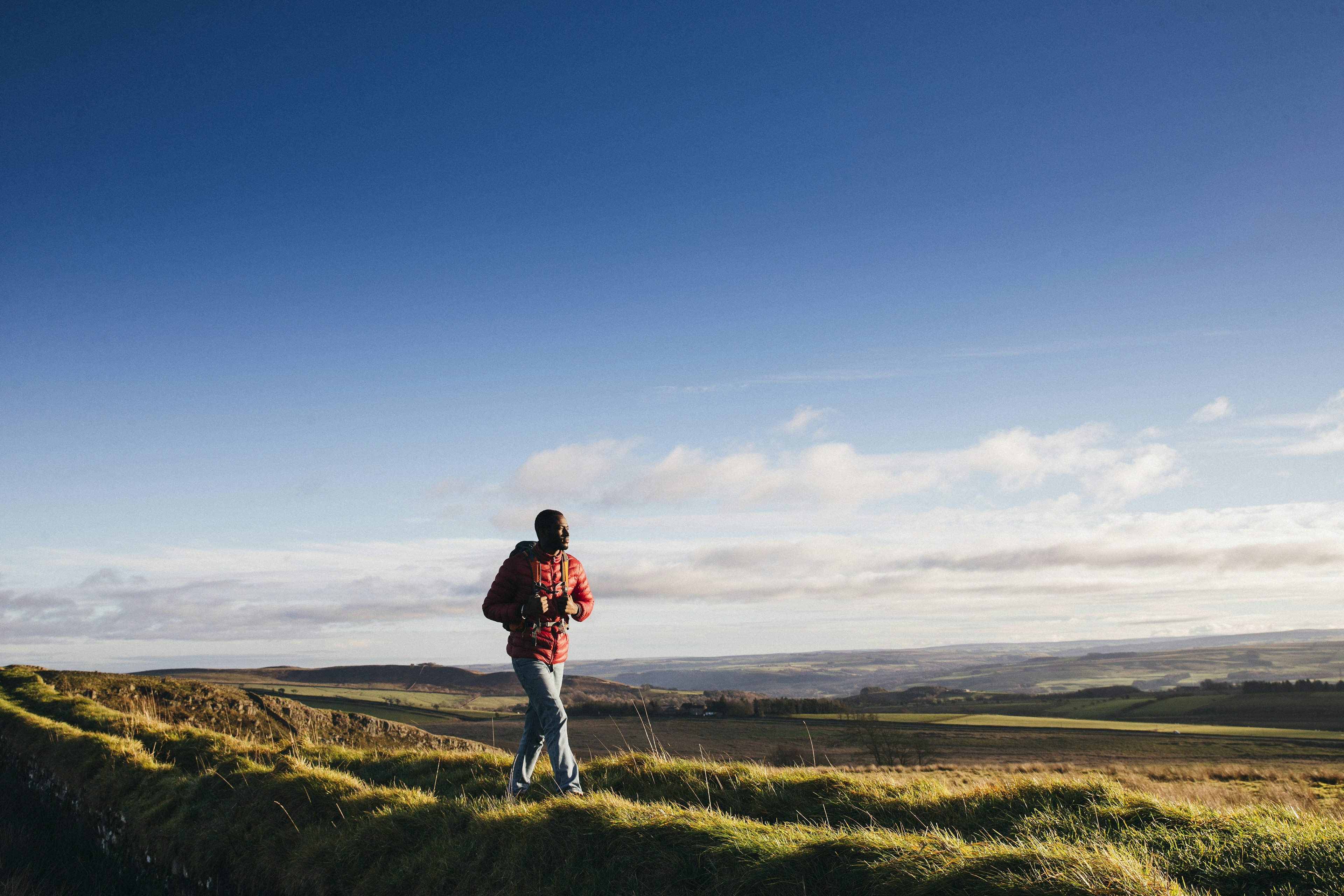 Man walking on Hadrian's Wall in Northumberland countryside