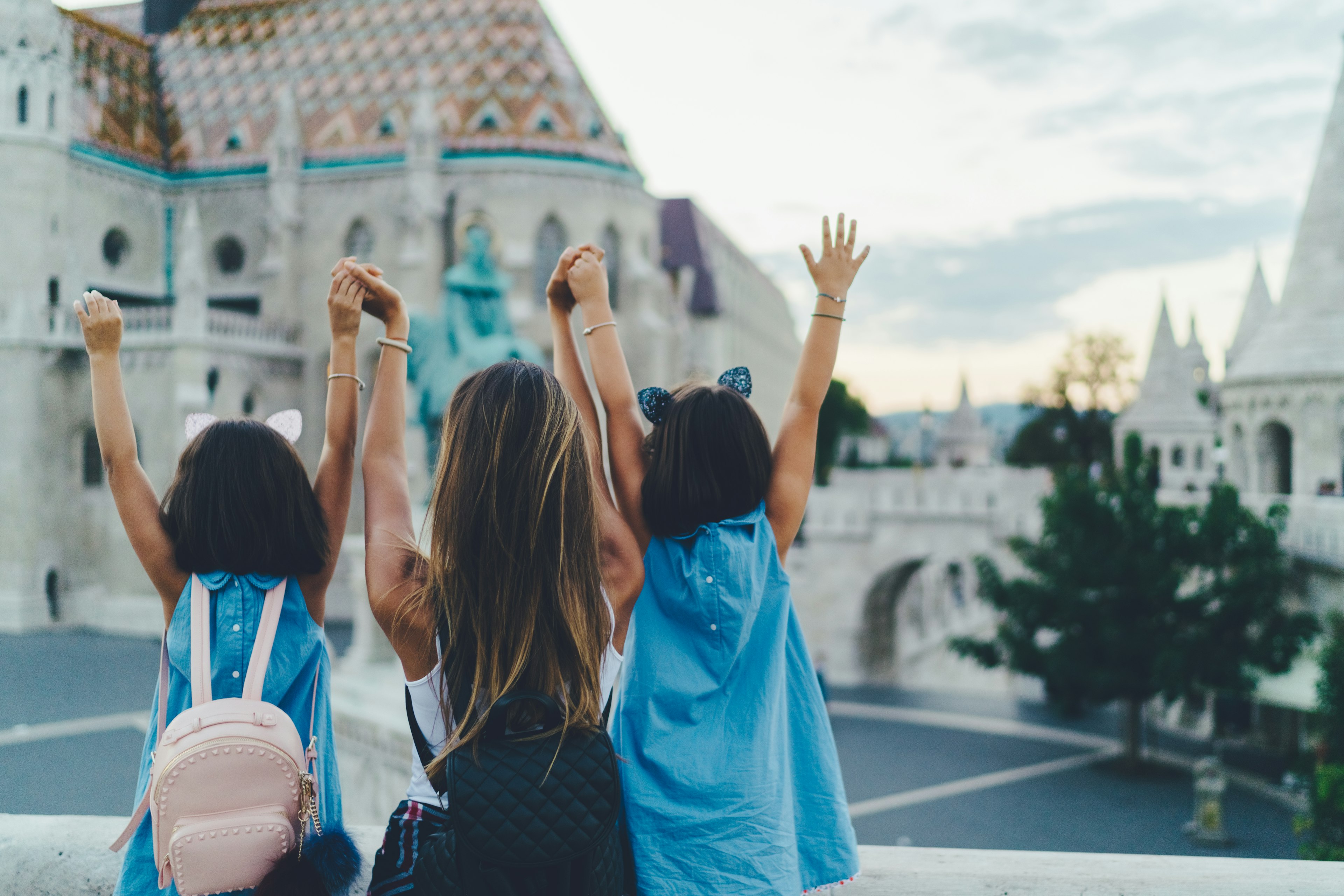 Mother with daughters enjoying Budapest, with the Halászbástya or Fisherman's Bastion blurred in the background